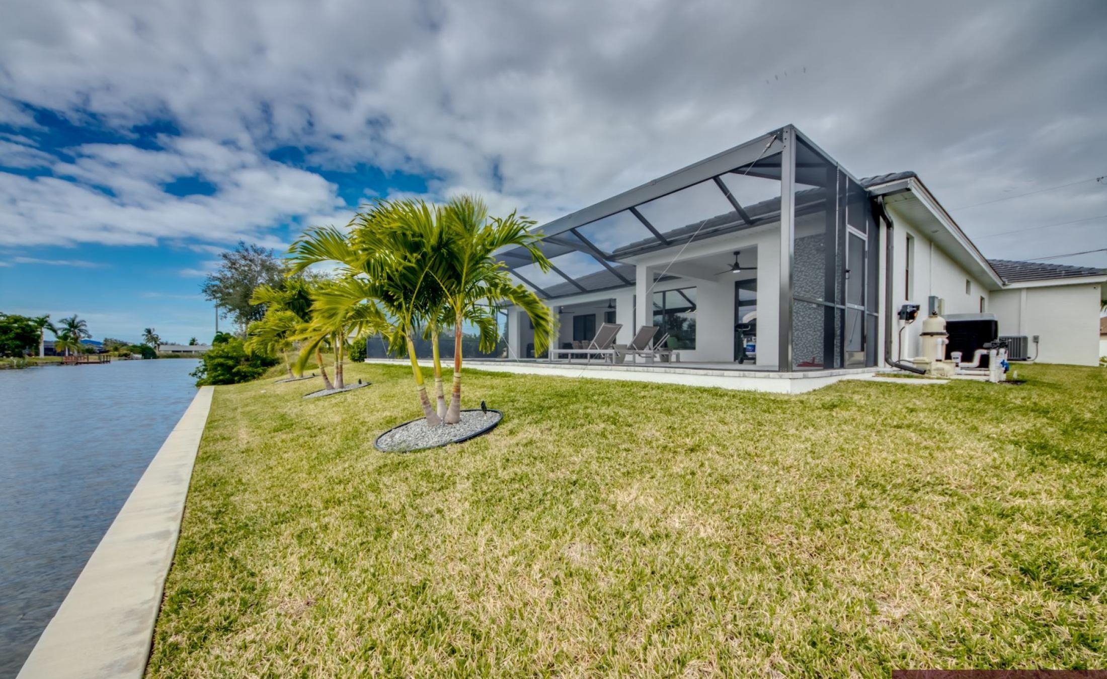Sonnige Poolterrasse mit beheiztem Pool und Spa am Frischwasserkanal.