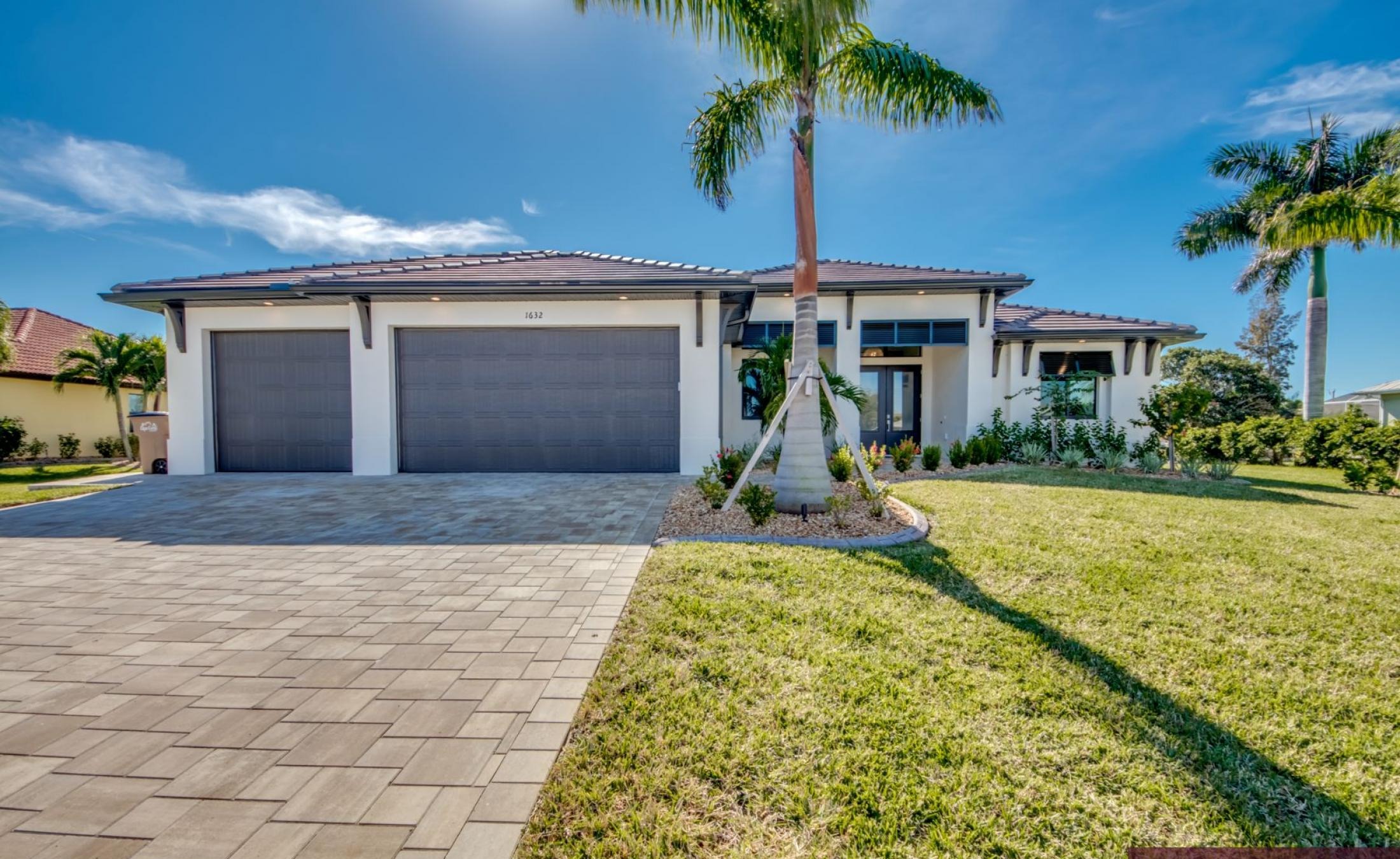 Moderner Poolbereich mit beheiztem Pool, Spa und Sonnenliegen am Kanal mit Bootsdock.