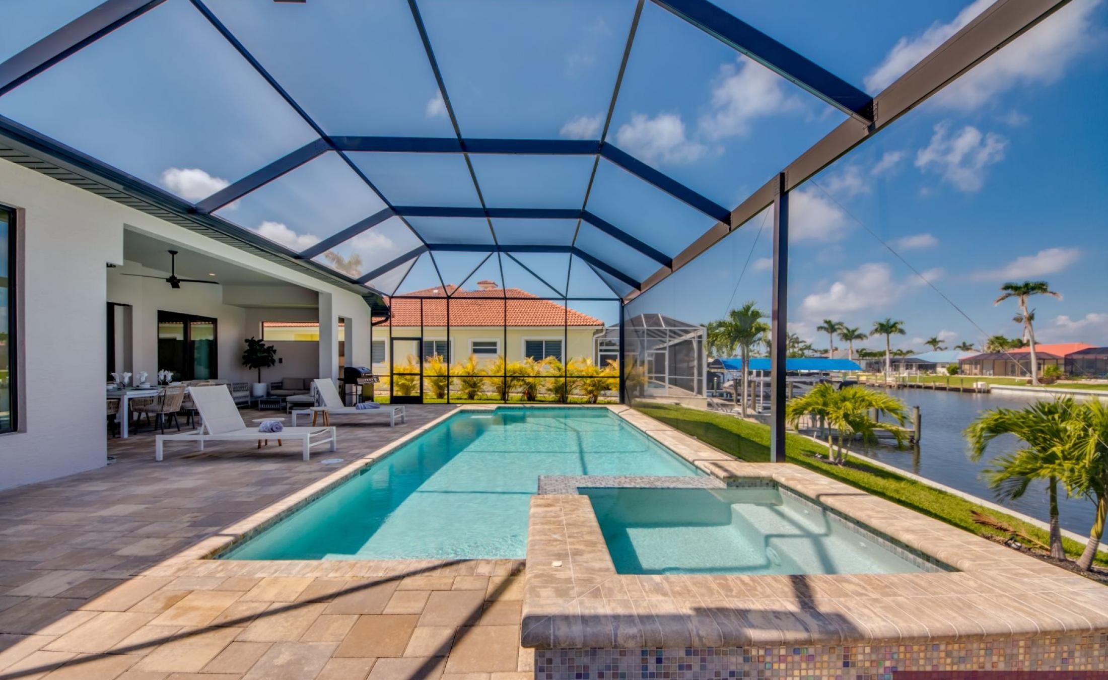 Elektrisch beheizter Pool und Spa mit Blick auf den Kanal bei Sonnenuntergang.