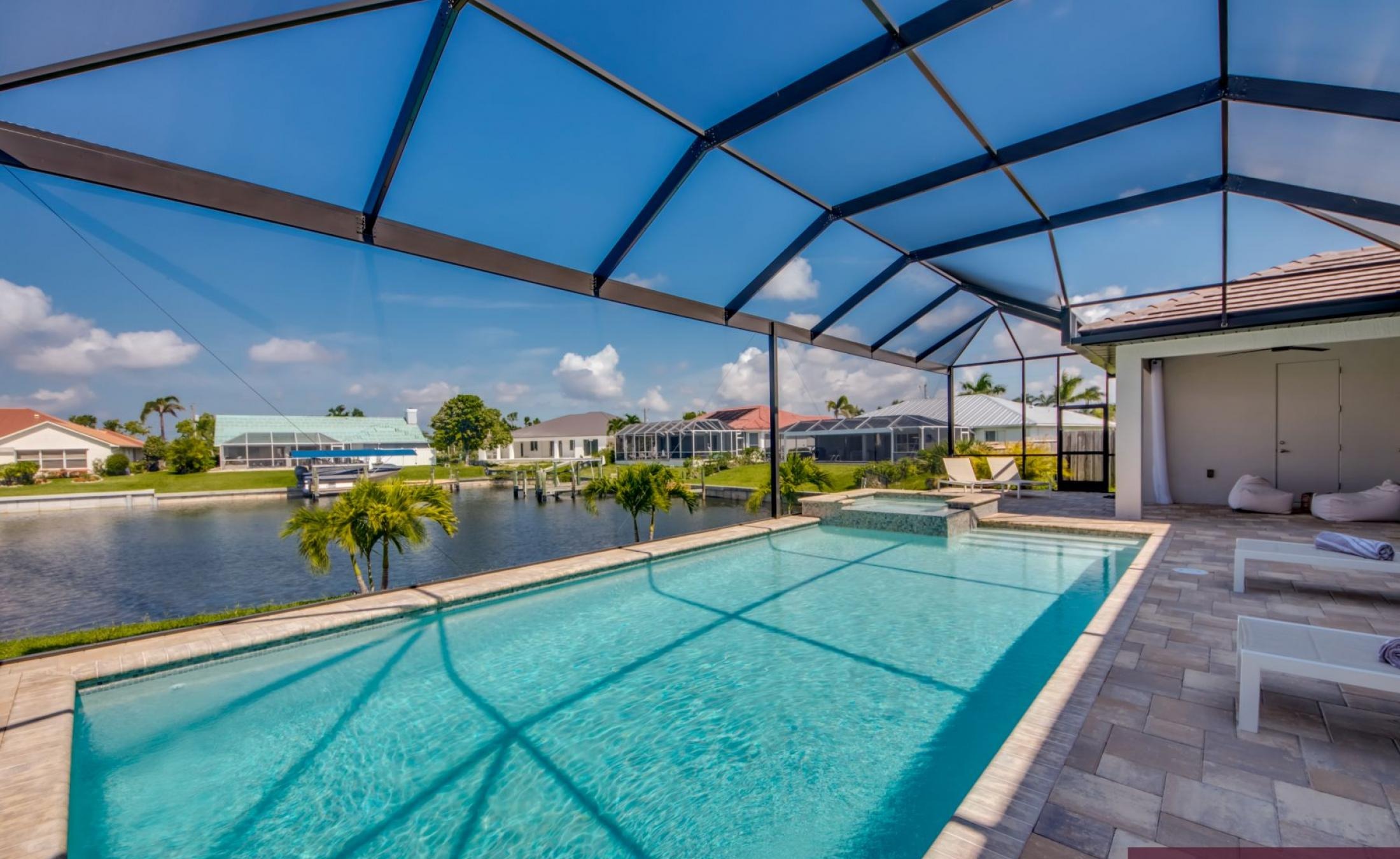 Elektrisch beheizter Pool und Spa mit Blick auf den Kanal bei Sonnenuntergang.