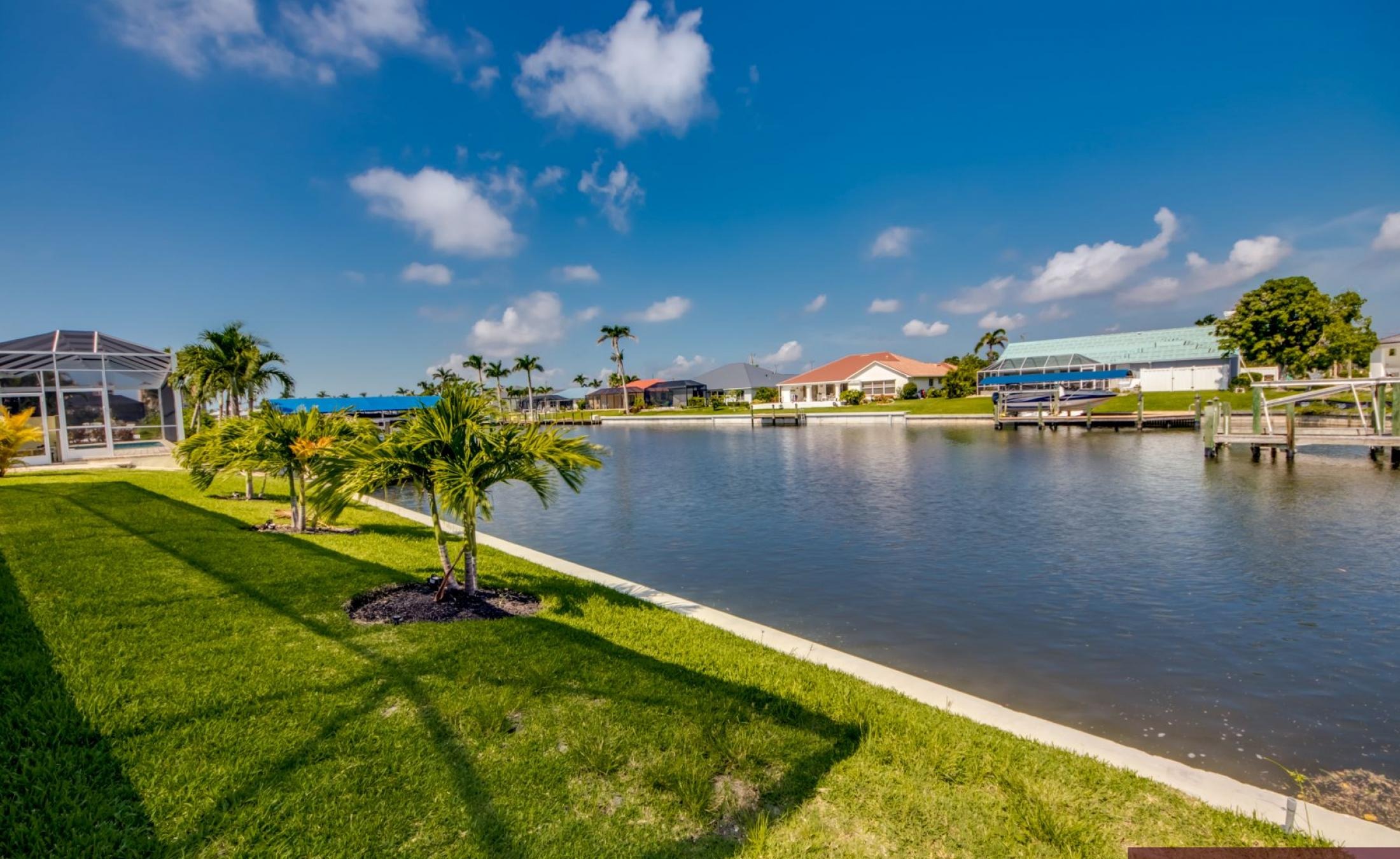 Privates Bootsdock mit Bootslift am Kanal (Gulf Access) bei Sonnenuntergang.