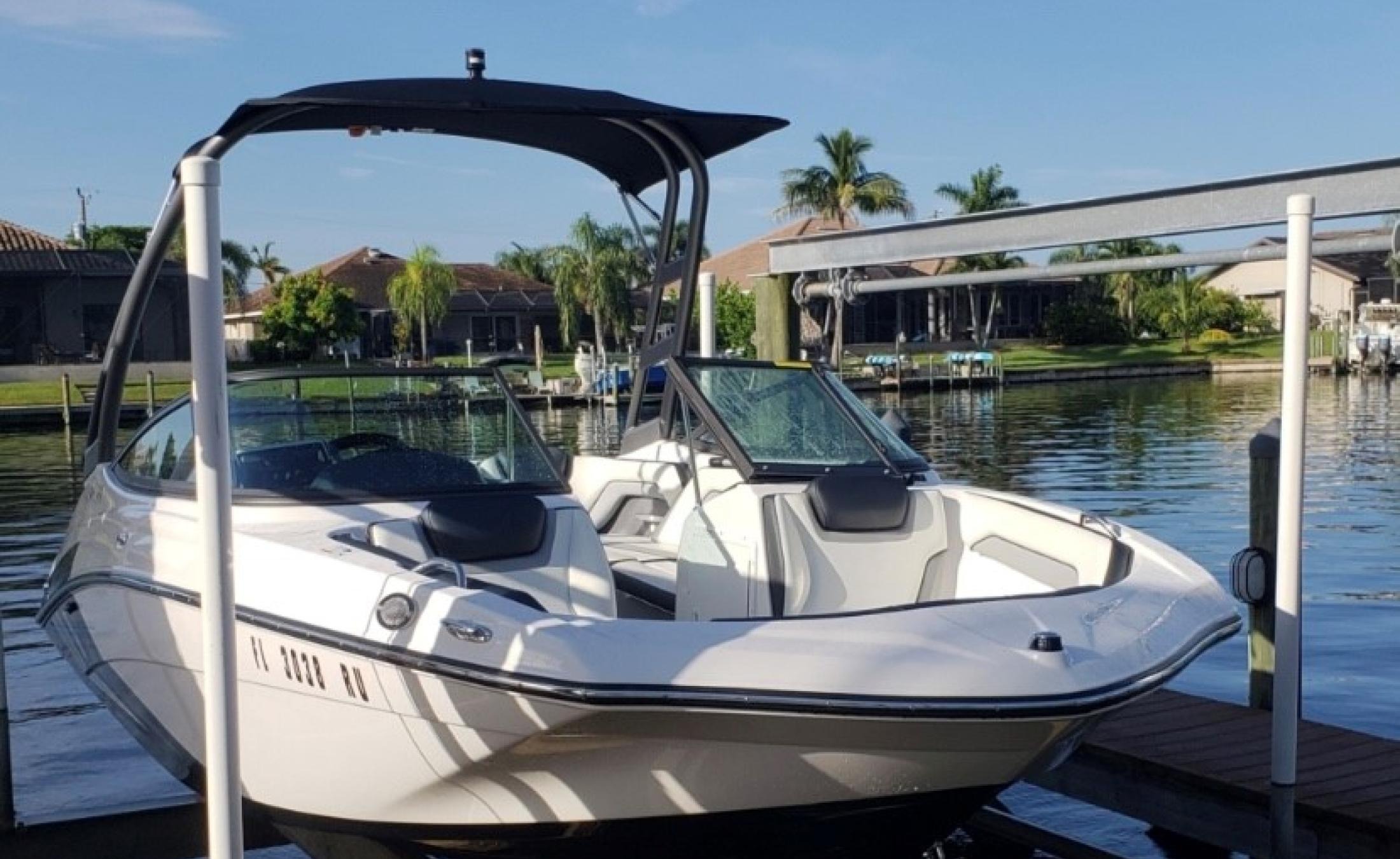 Privates Bootsdock mit Bootslift am Kanal (Gulf Access) bei Sonnenuntergang.