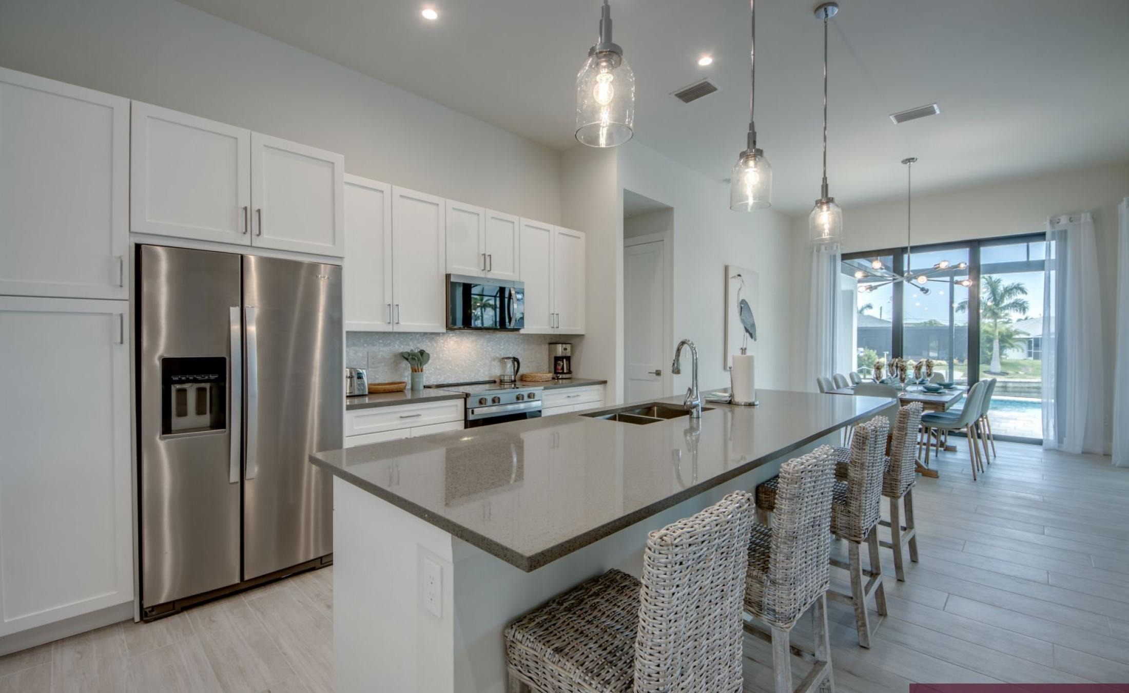 Pooldeck mit beheiztem Pool und Spa am Wasser mit privatem Bootsdock und Bootslift bei Sonnenuntergang.