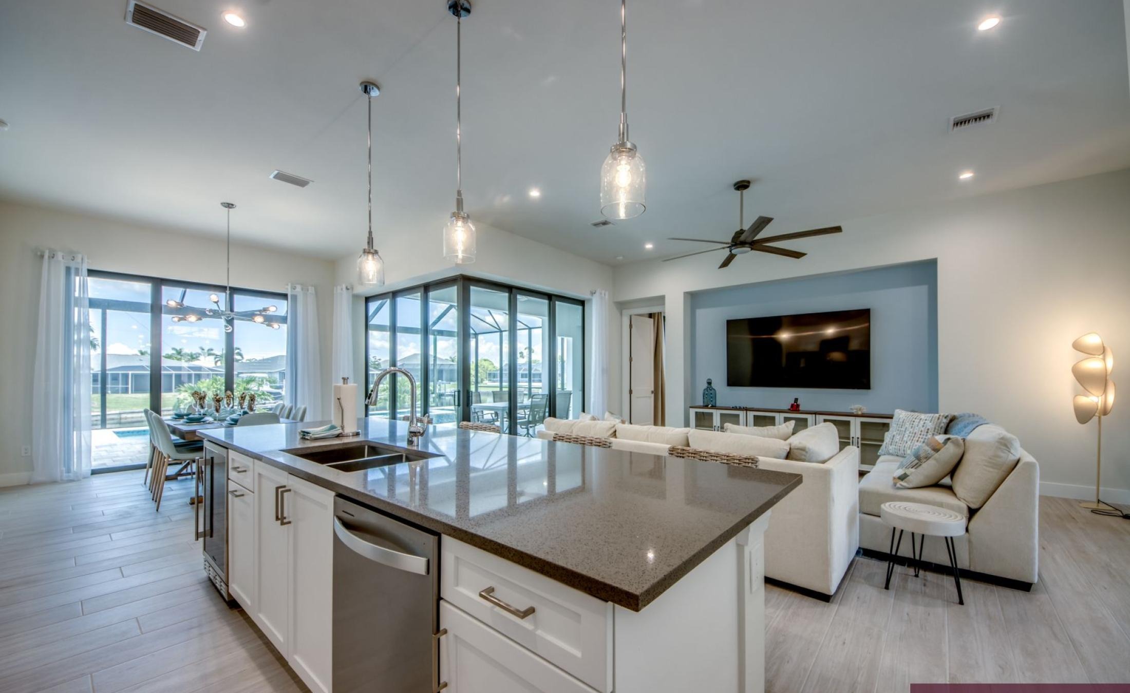 Pooldeck mit beheiztem Pool und Spa am Wasser, Blick auf Kanal und privates Bootsdock.