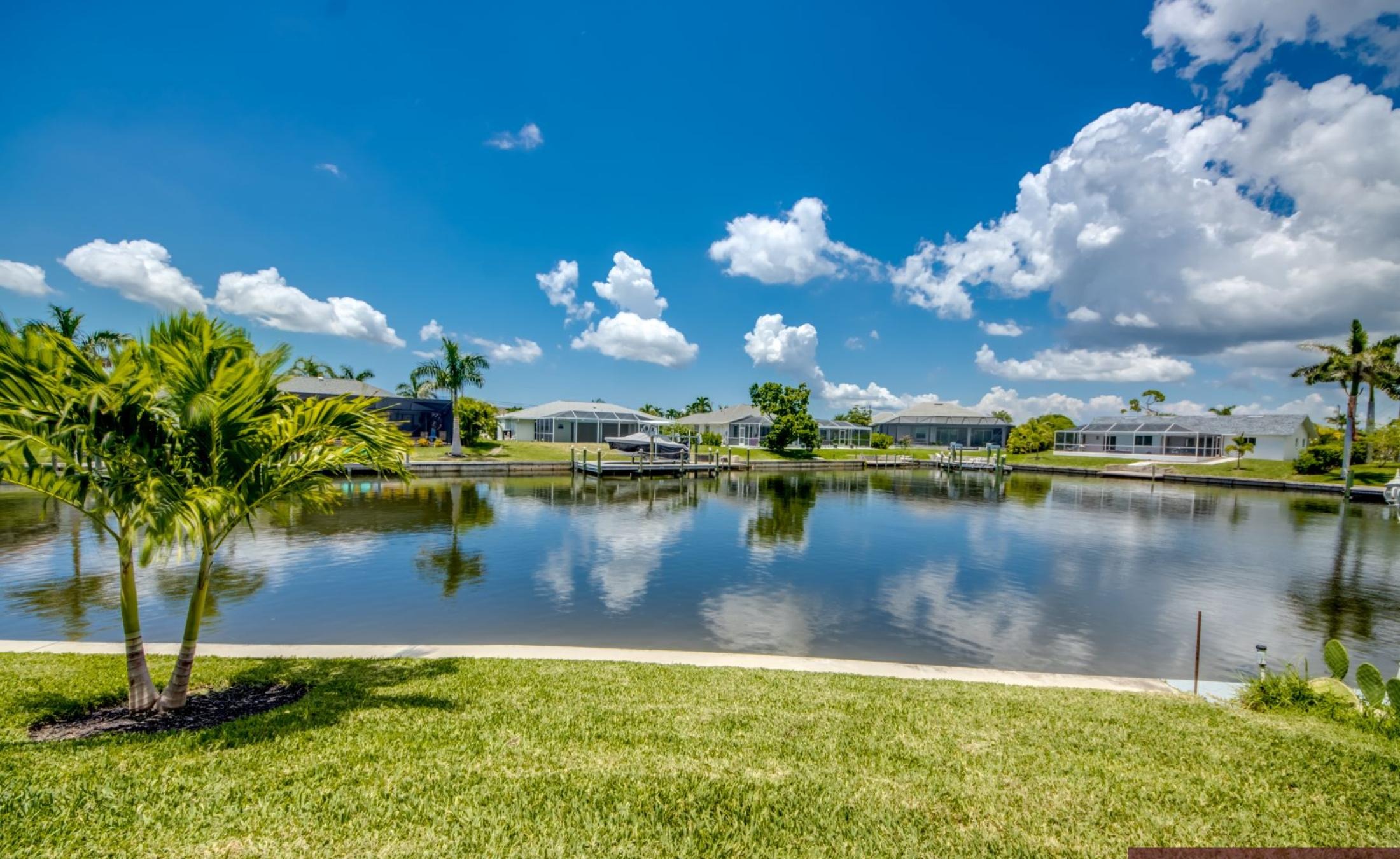 Pooldeck am Wasser mit privatem Dock und Bootslift bei Sonnenuntergang.