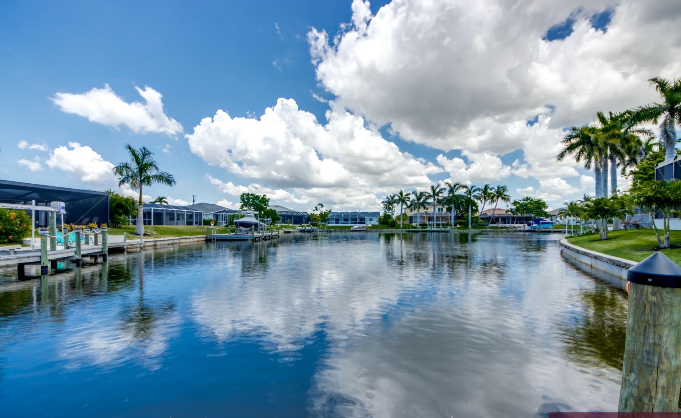 Privates Bootsdock mit Bootslift am Kanal bei Sonnenuntergang.