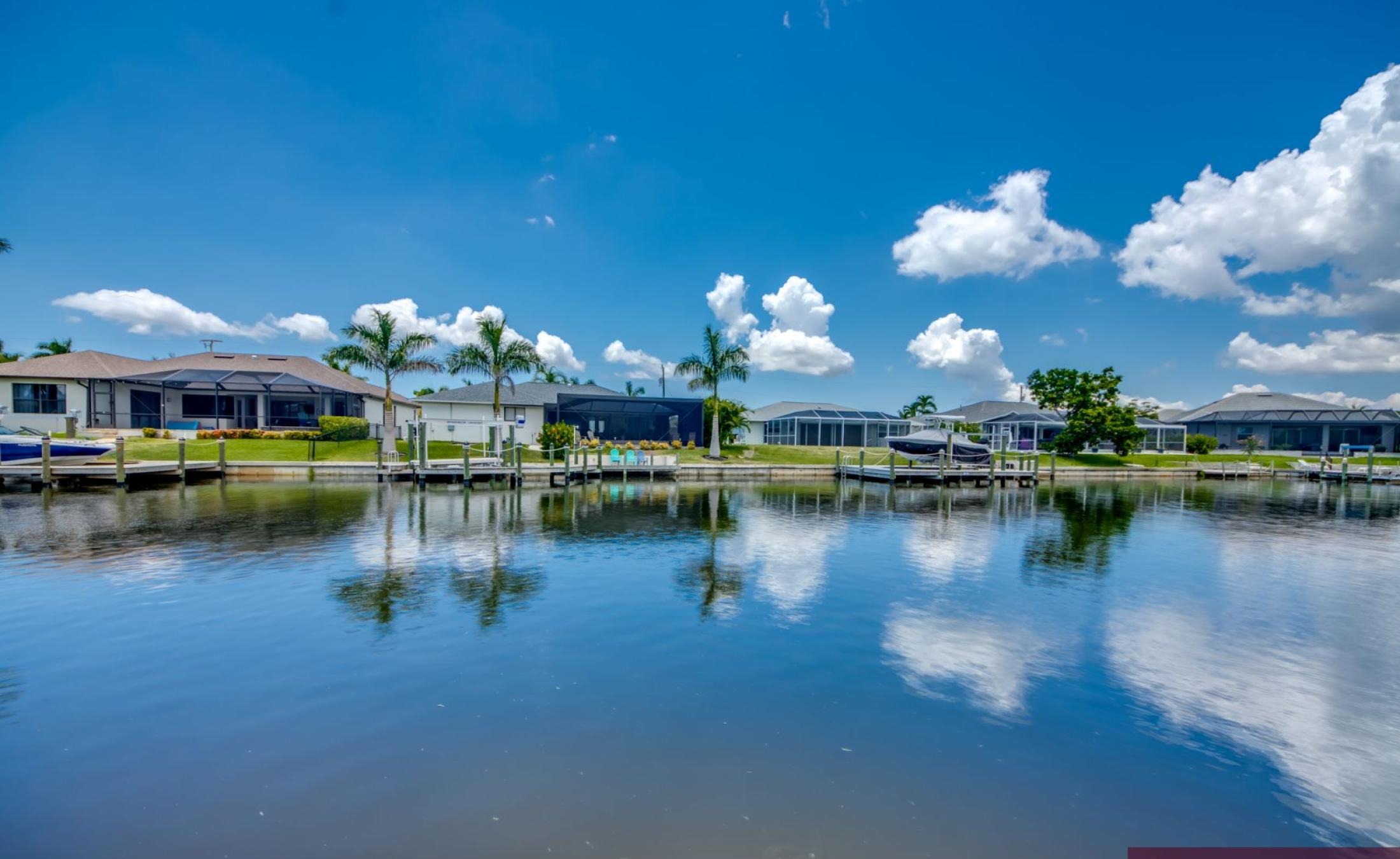 Privates Bootsdock mit Bootslift am Kanal bei Sonnenuntergang.