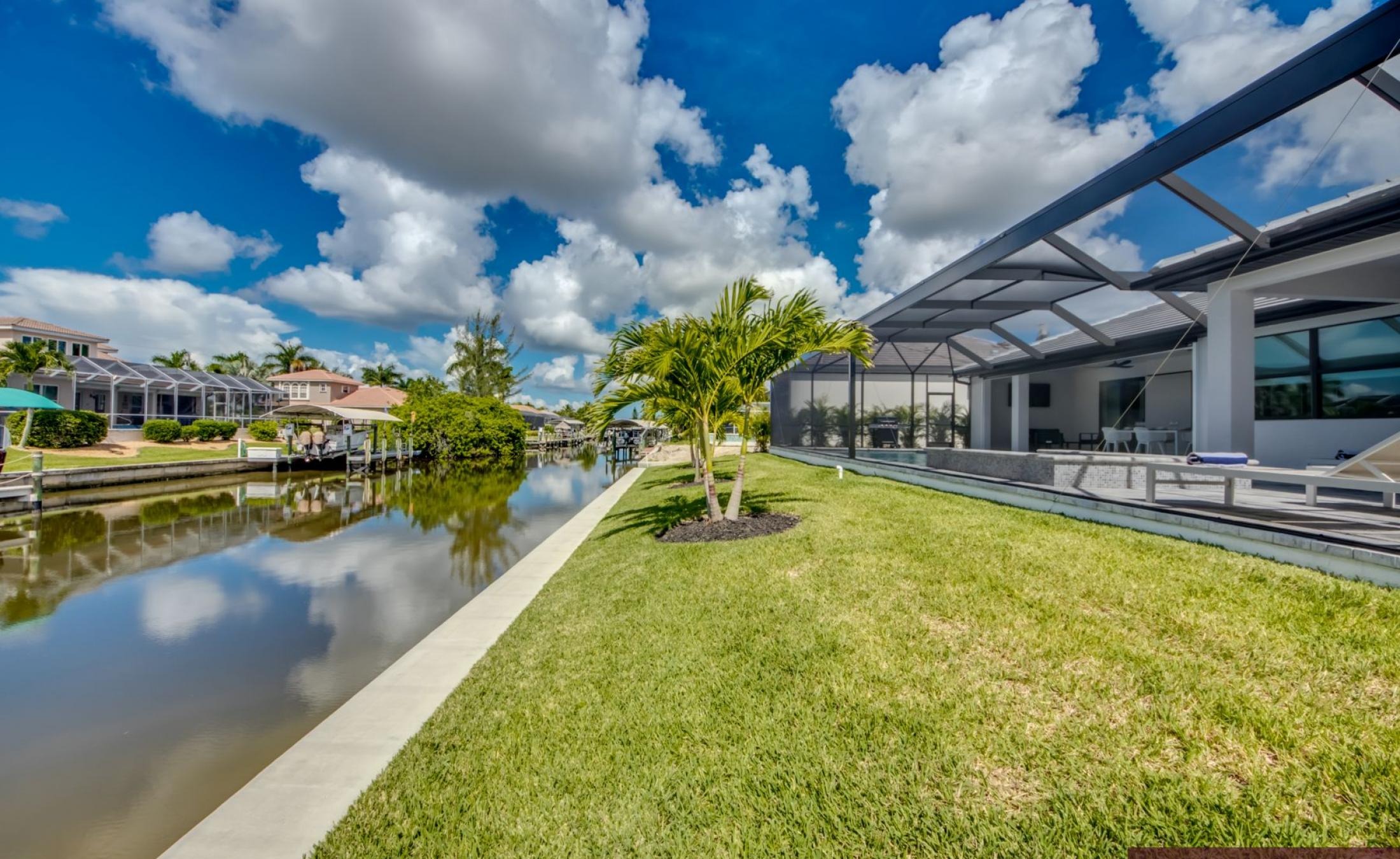 Sonniges Pooldeck mit elektrischem Pool und Spa am Kanal.