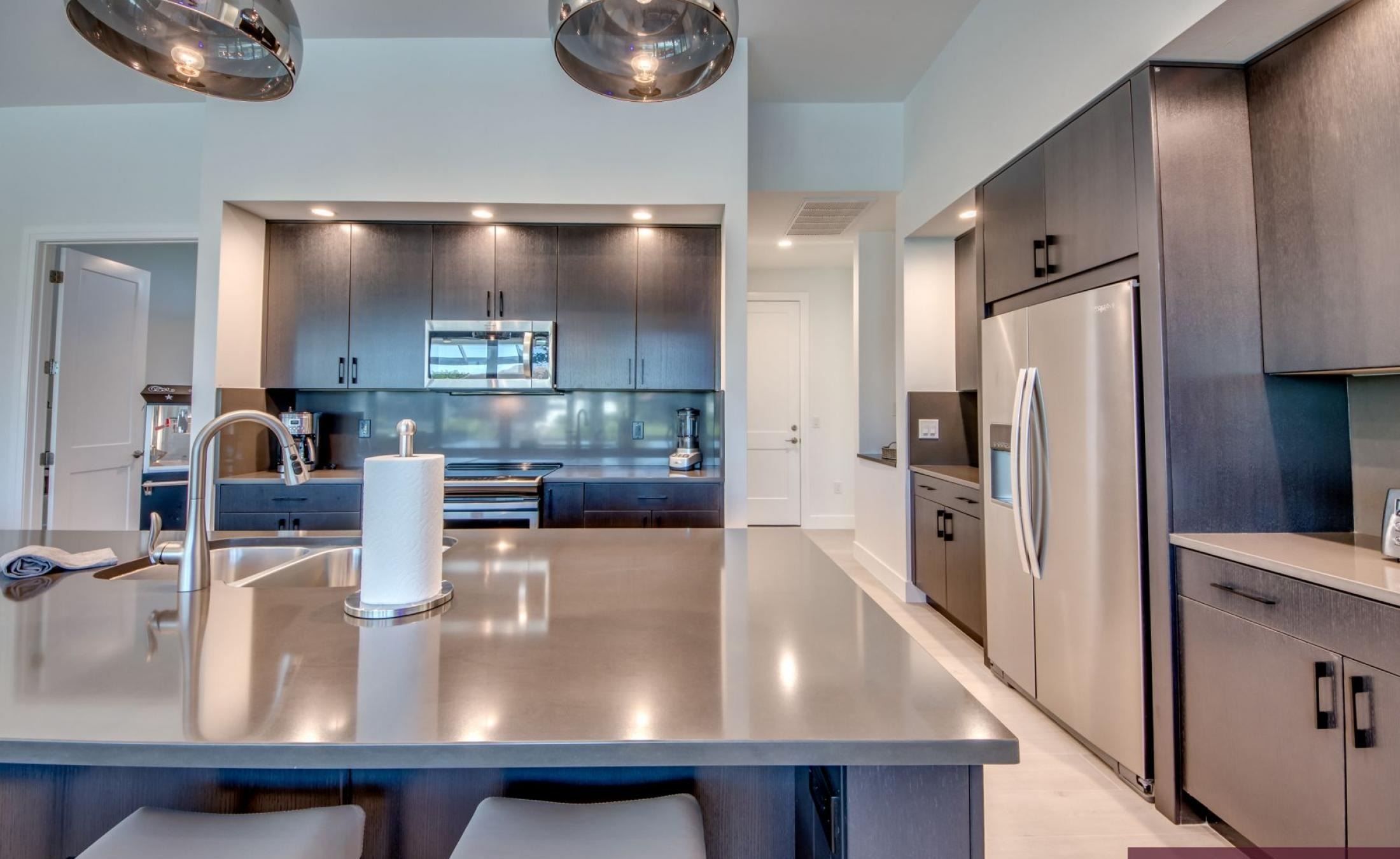 Sonnige Poolterrasse am Kanal mit Bootsdock und Sitzbereich.