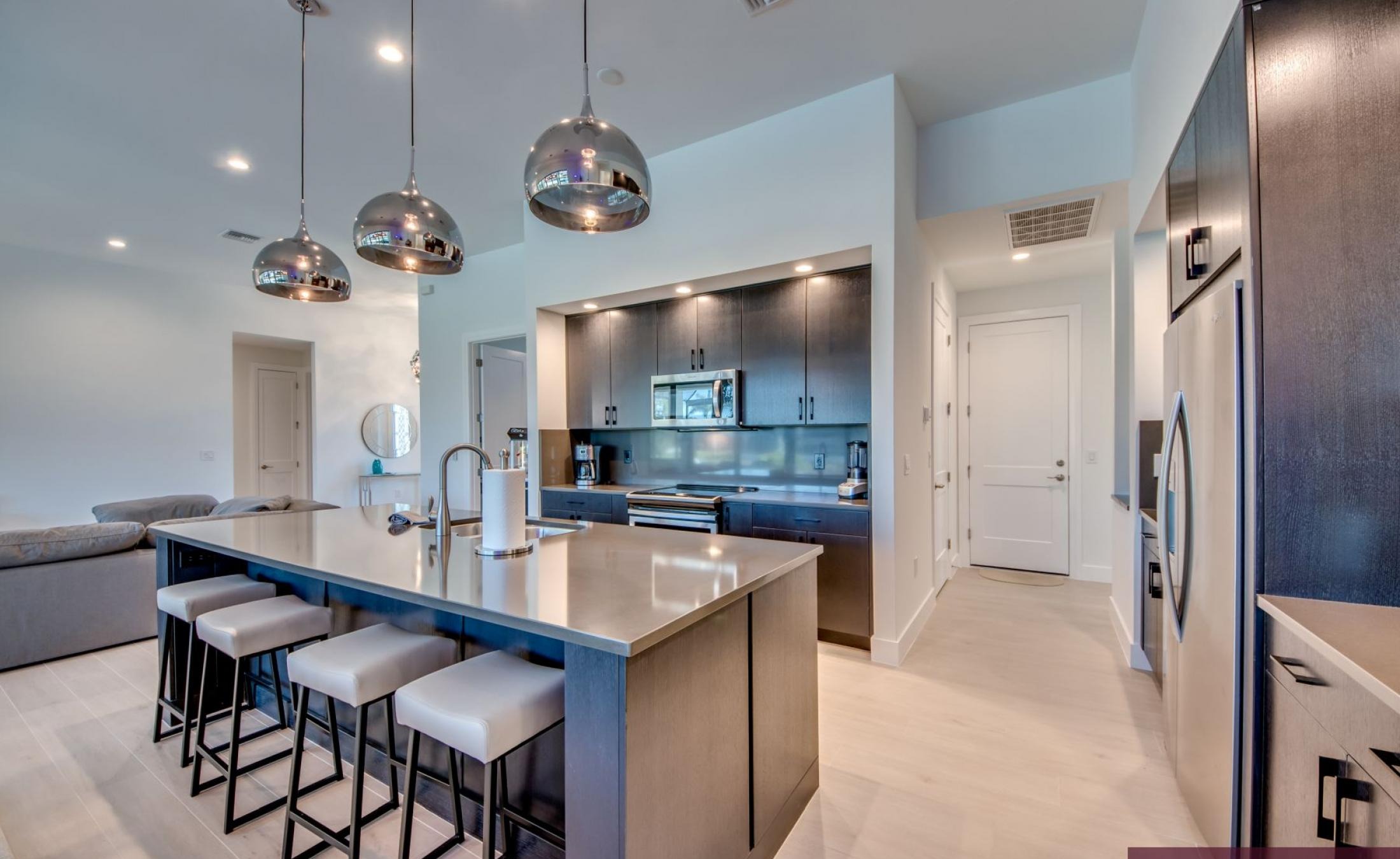 Südlich ausgerichteter Poolbereich mit Liegen und Blick auf den Kanal.