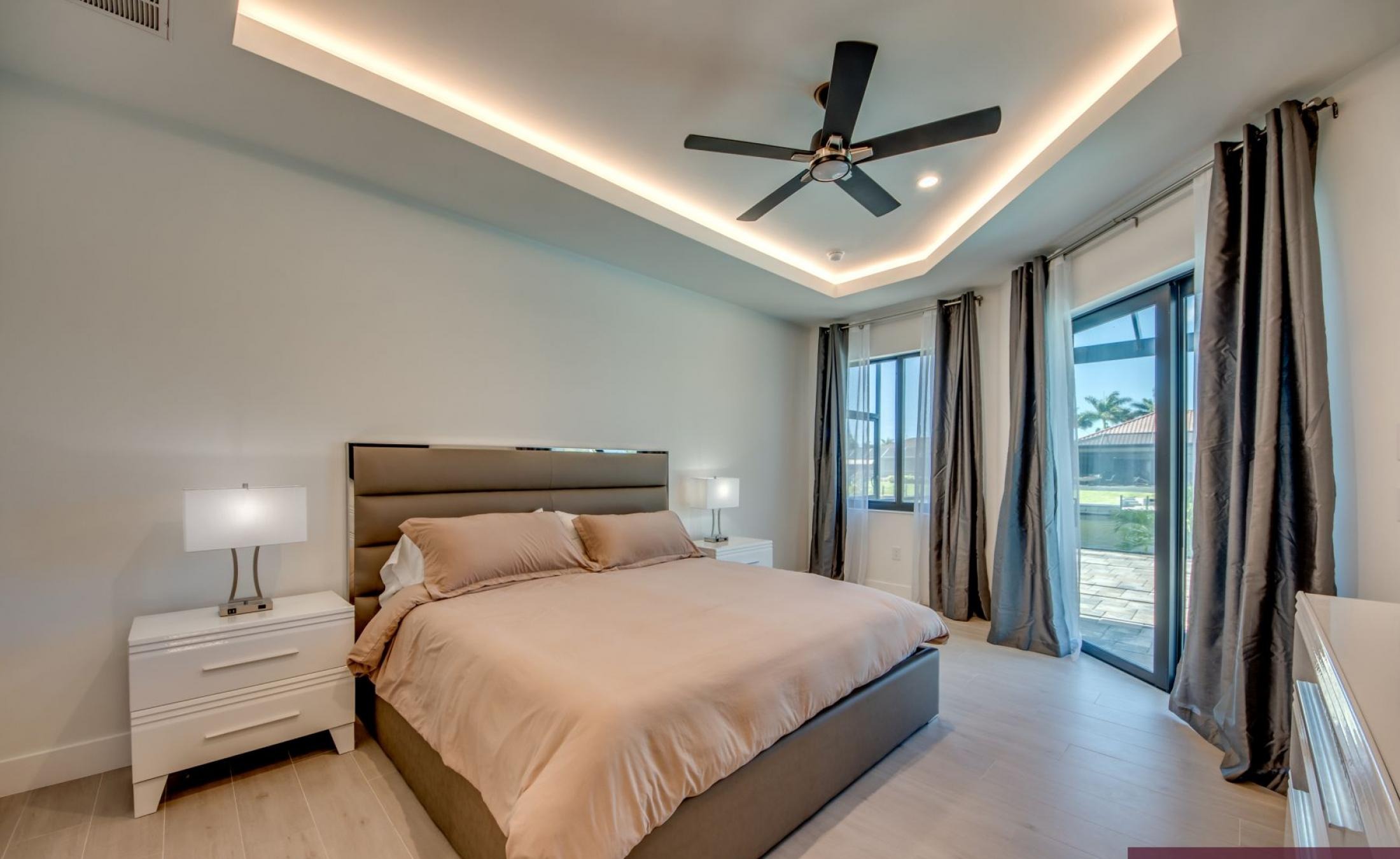 Sonnige Poolterrasse am Kanal mit Dock und Blick aufs Wasser.