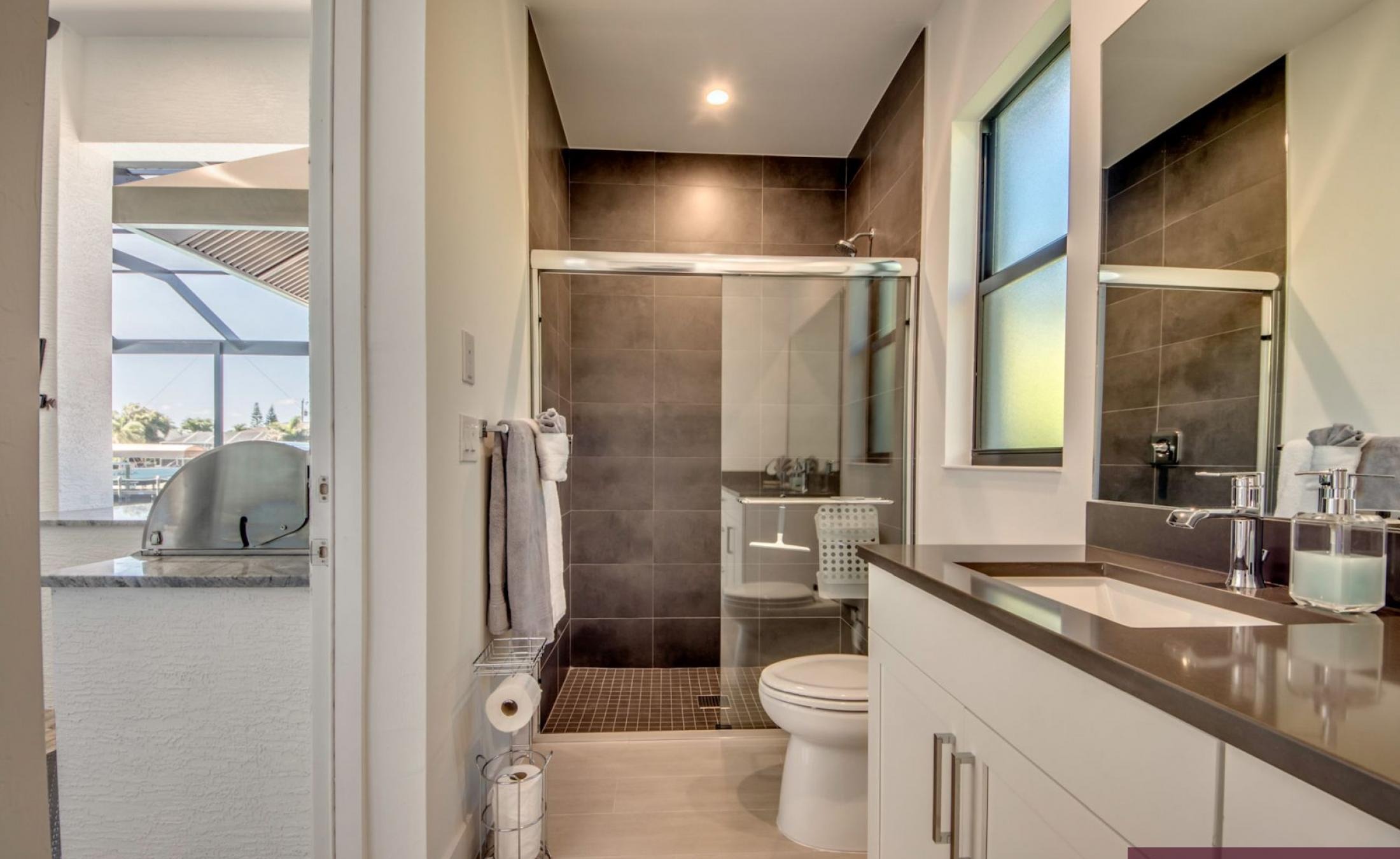 Sonnige Poolterrasse mit Blick auf den Kanal und Bootsdock.