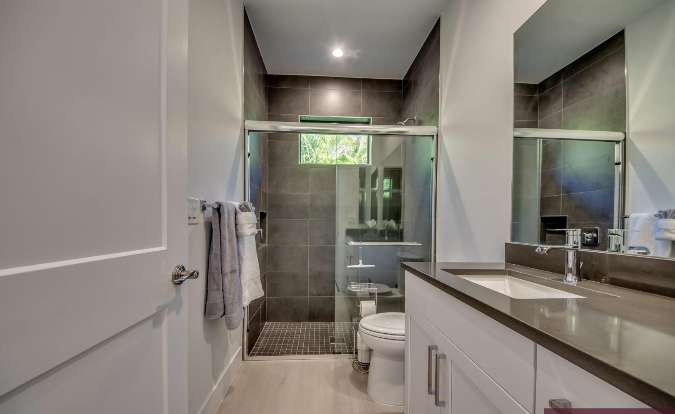 Südlich ausgerichteter Poolbereich mit Spa, Liegen und Blick auf den Kanal.