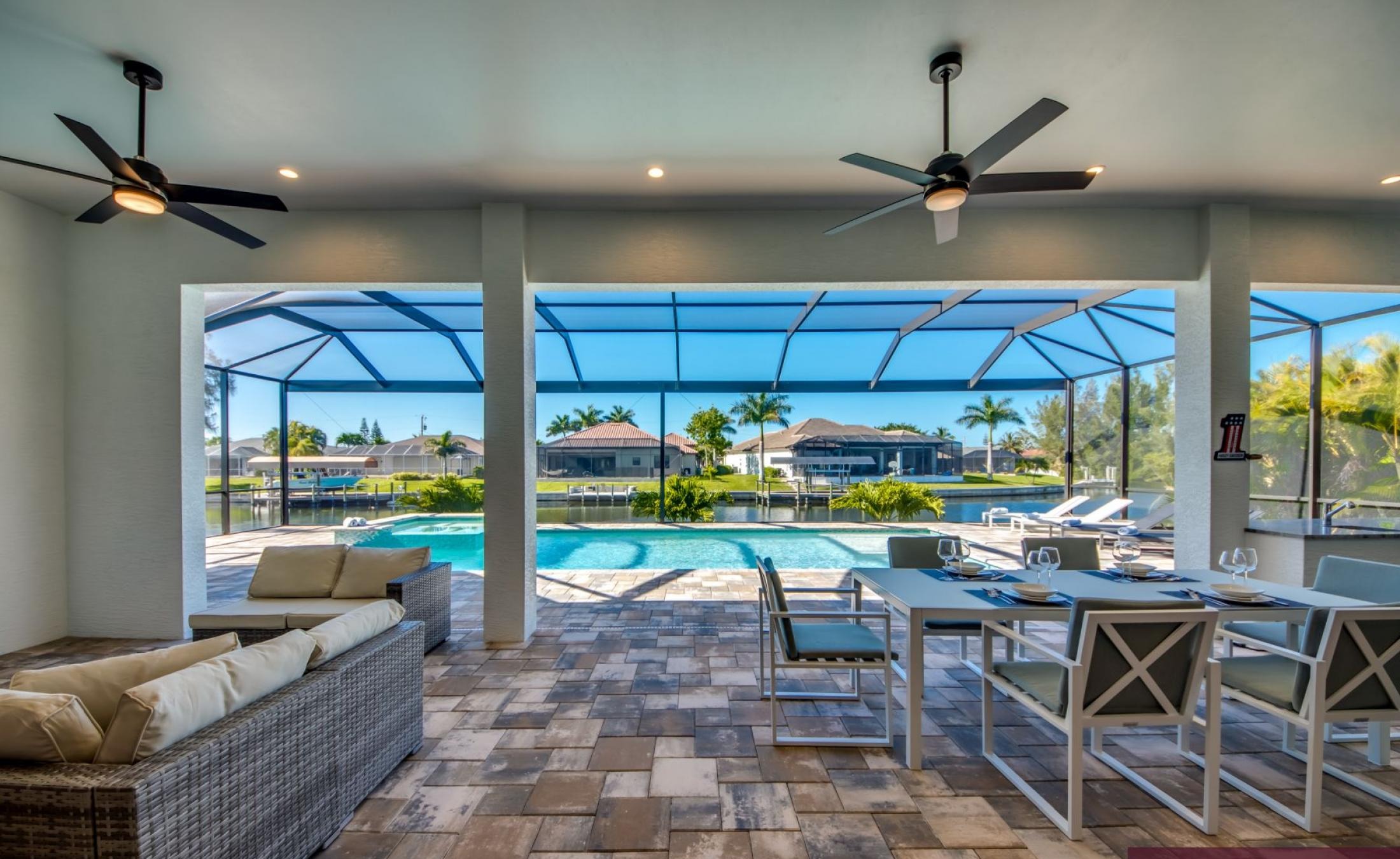 Sonnige Poolterrasse mit Blick auf den Kanal und Bootsdock.