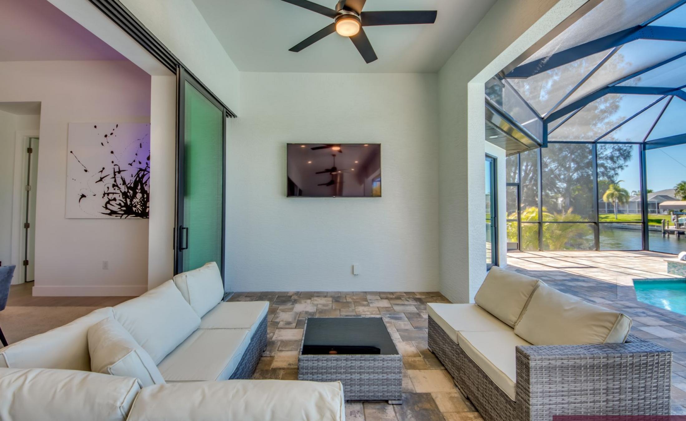 Sonnige Poolterrasse am Kanal mit Liegen und Bootsdock.