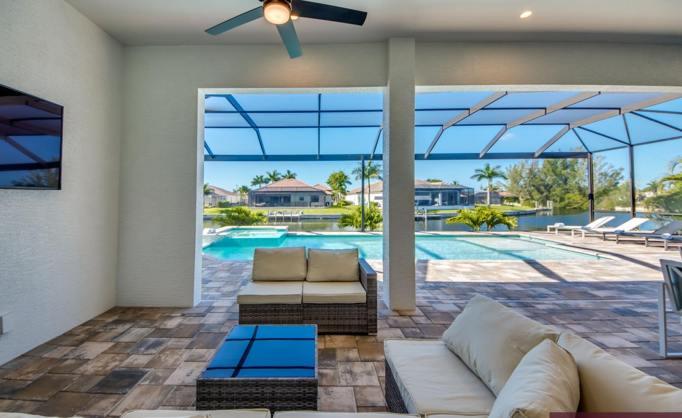 Sonnige Poolterrasse mit Blick auf den Kanal und privatem Bootsdock.