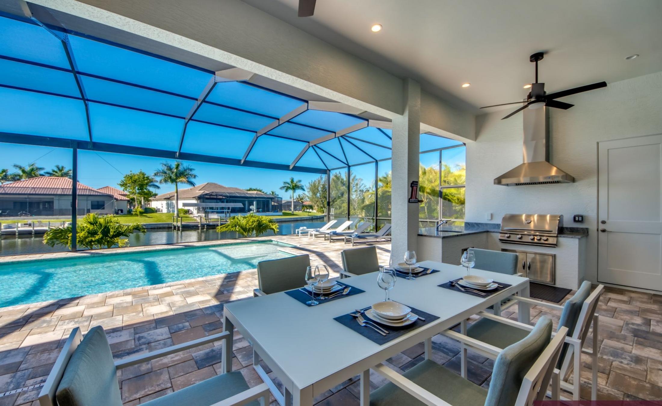 Privater Poolbereich mit Sonnenliegen und Blick auf den Kanal.