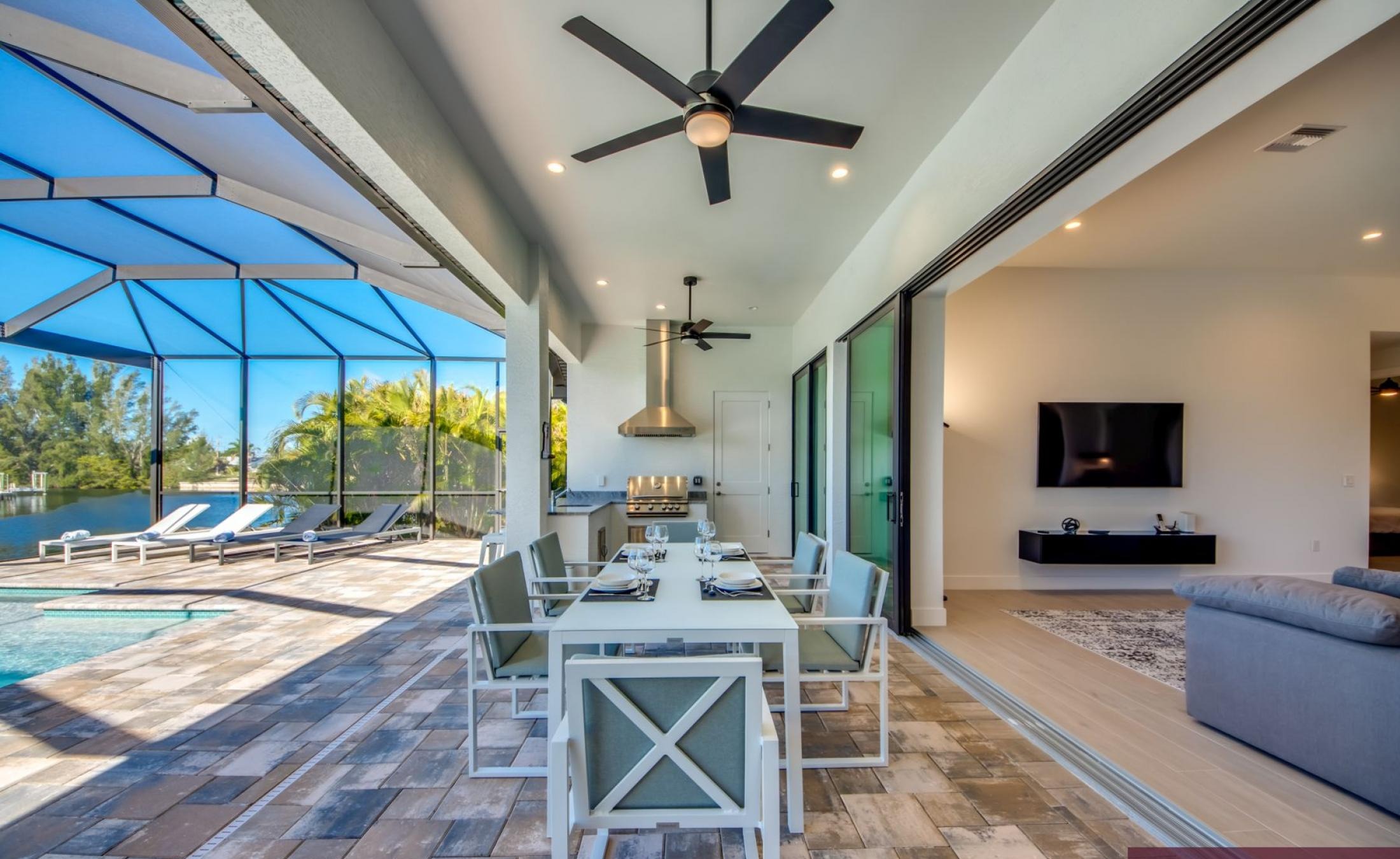 Sonnige Poolterrasse mit Blick auf den Kanal und Bootsdock.