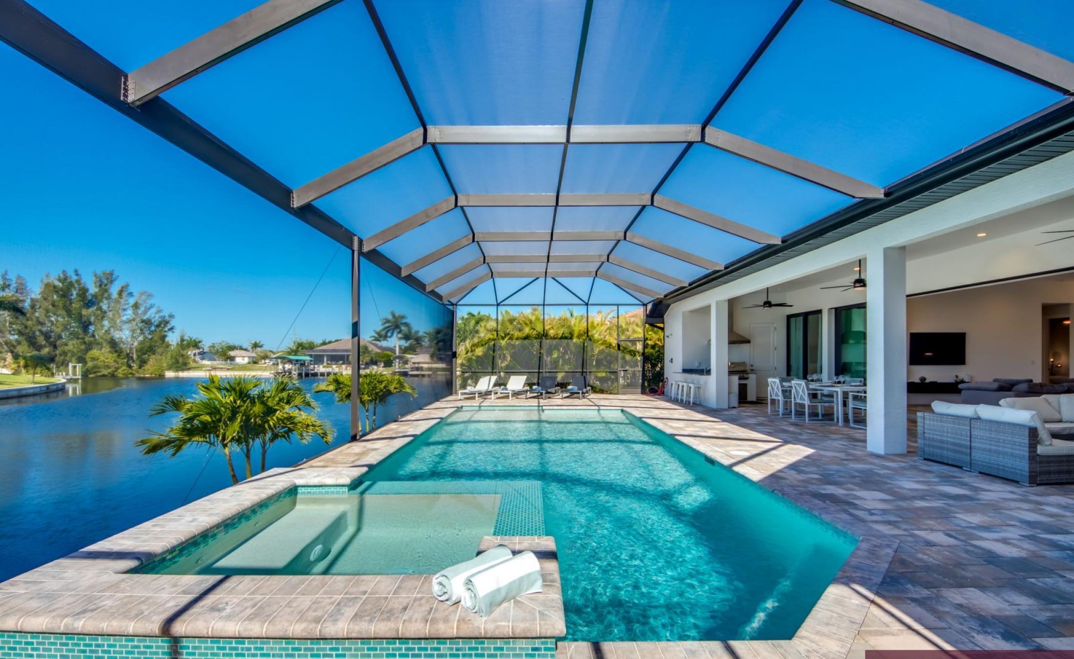 Sonnige Poolterrasse mit Blick auf den Kanal und Bootsdock.