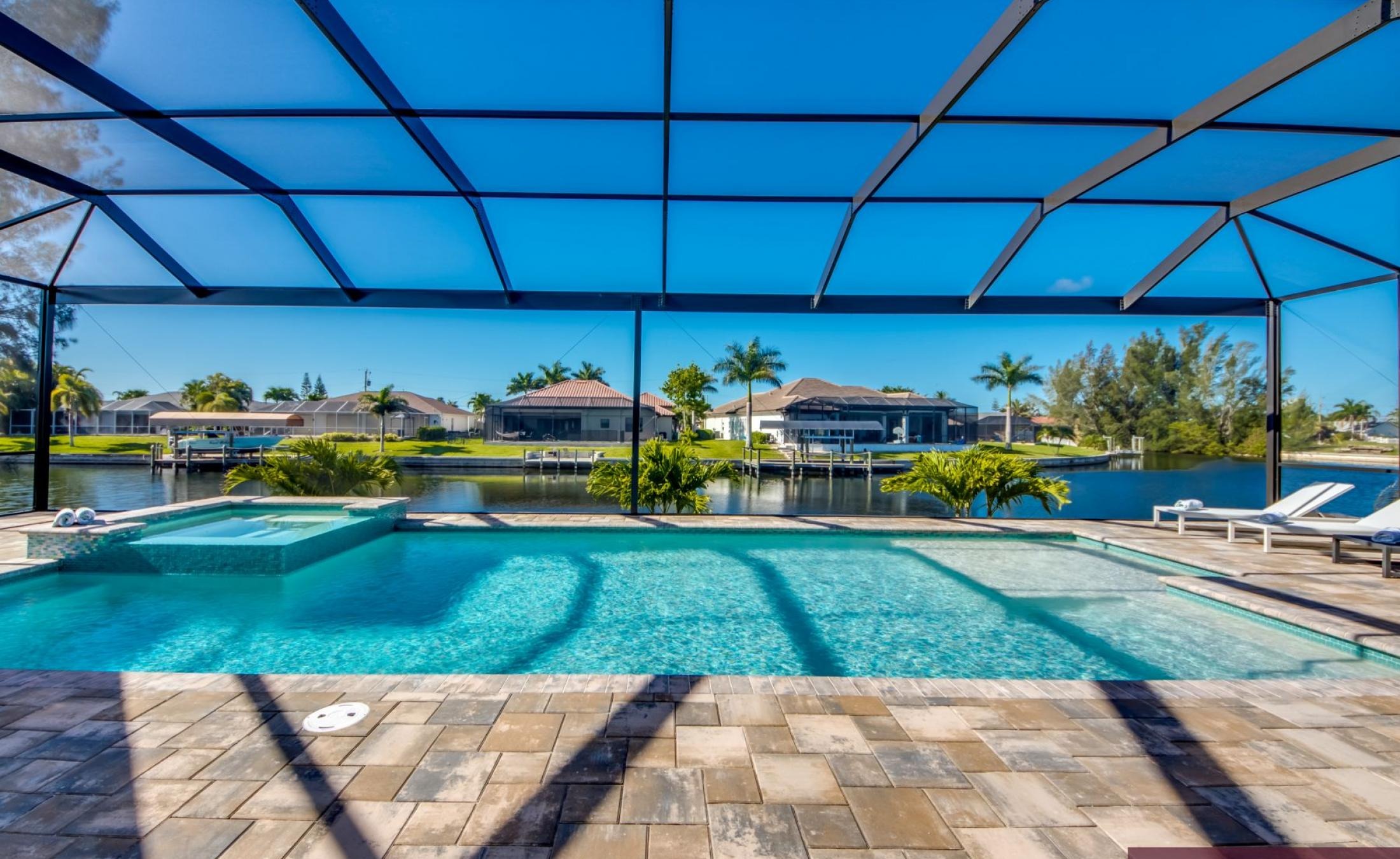 Sonnige Poolterrasse mit Blick auf den Kanal und Bootsdock.