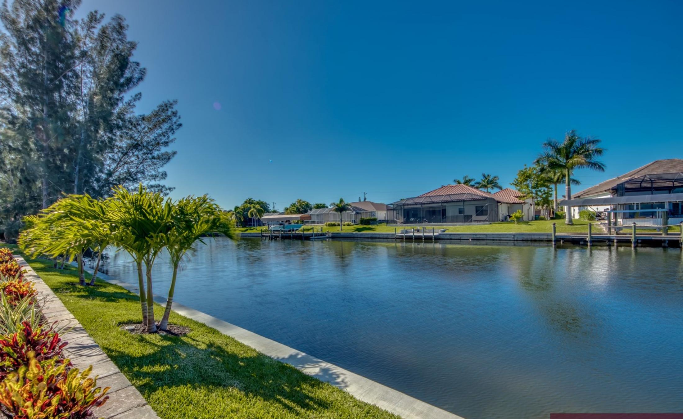 Sonniger Poolbereich am Kanal mit Spa und Bootsdock.