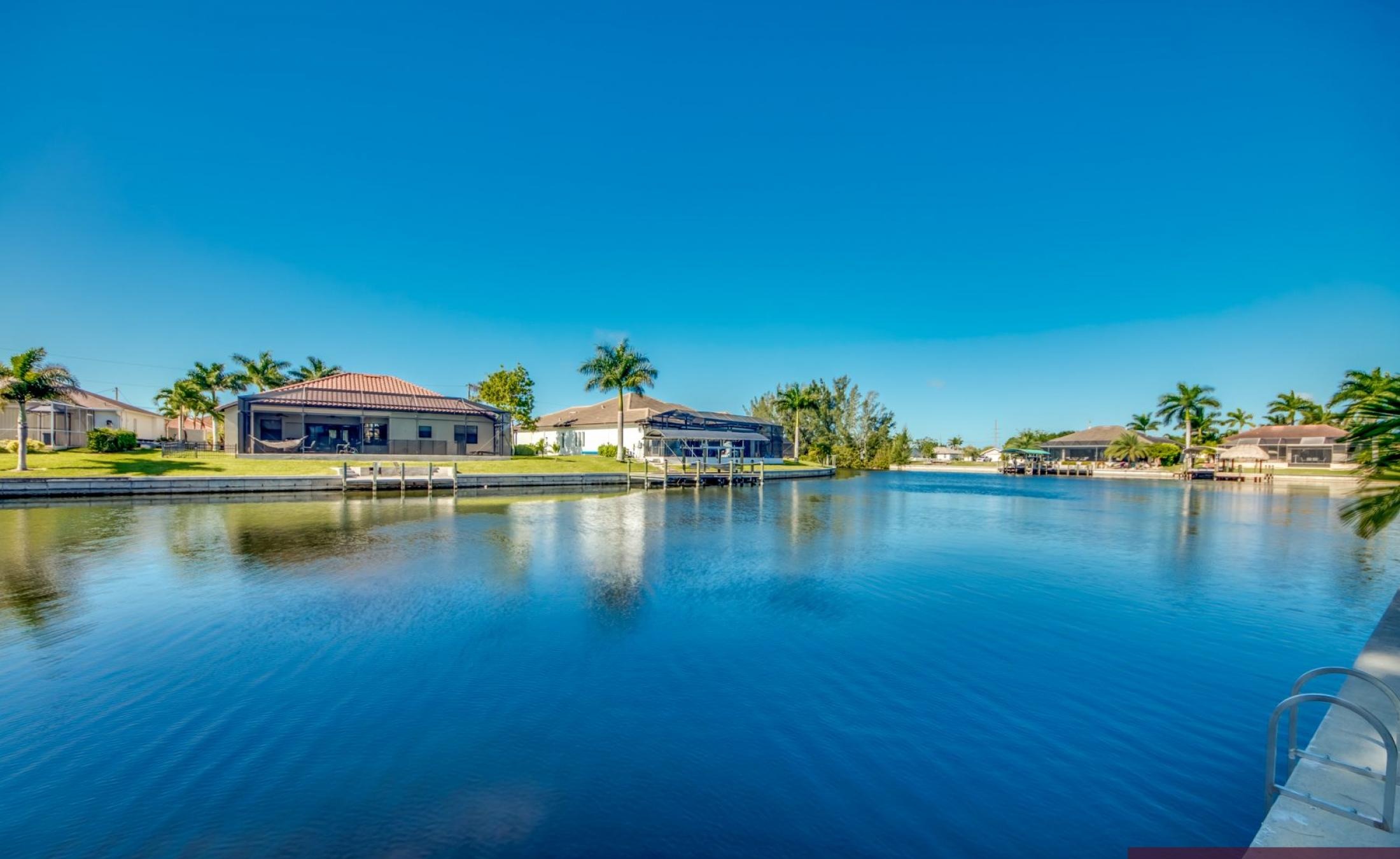 Südseitiger Poolbereich mit Liegen und Blick auf den Kanal.