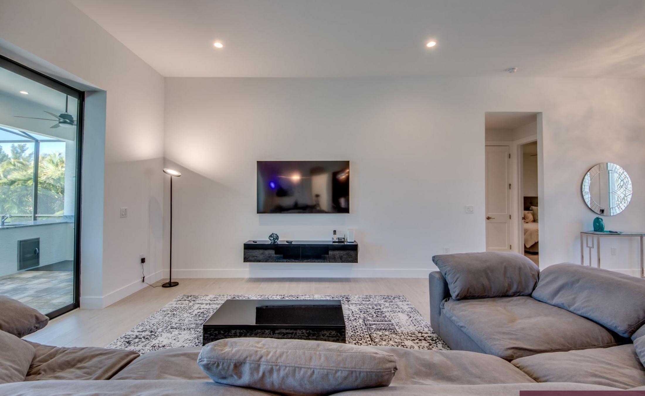 Sonniger Poolbereich mit Liegen und Blick auf den Kanal.