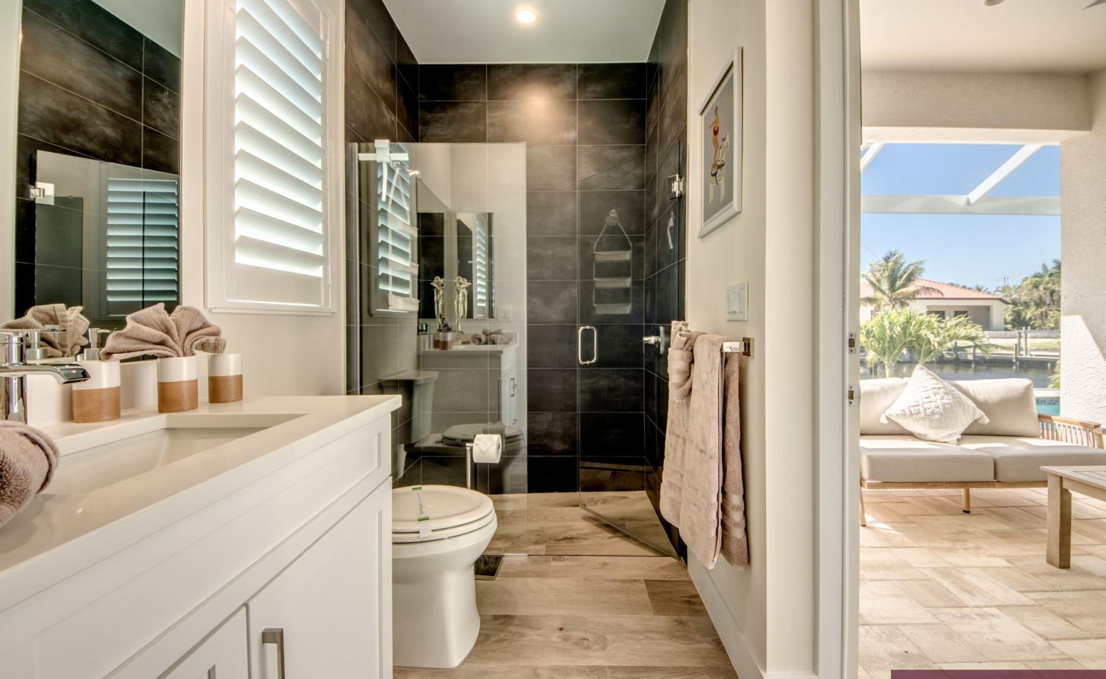 Sonniges Pooldeck mit Salzwasserpool, Spa und Blick auf den Kanal.