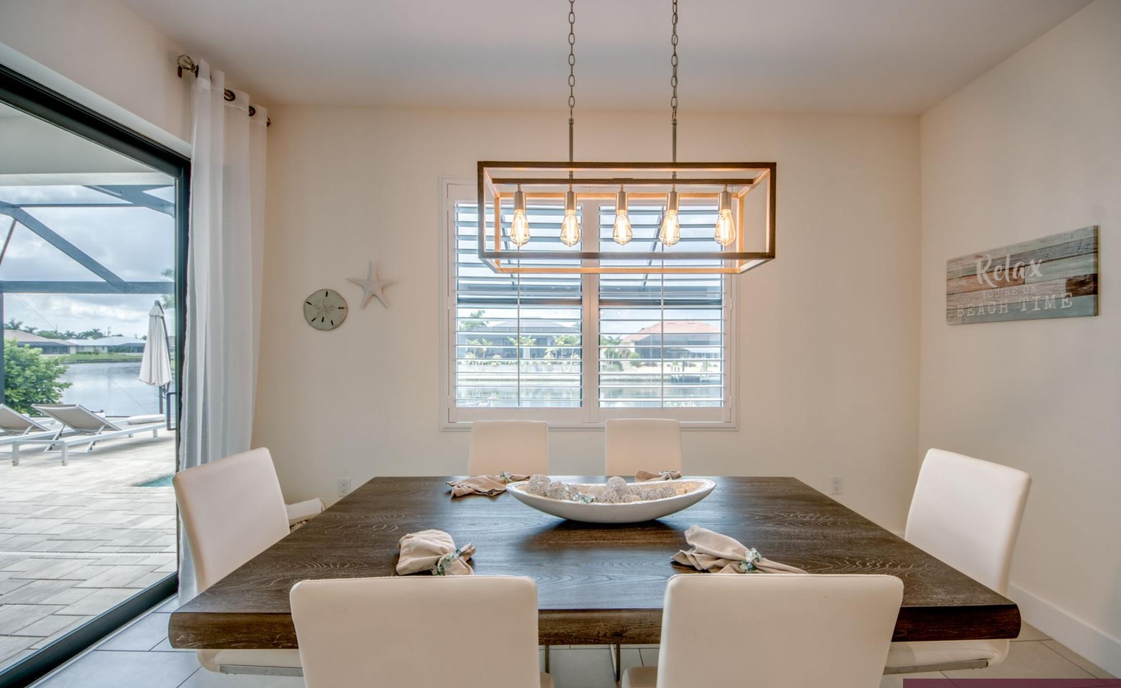 Beheizter Pool mit integriertem Spa auf der sonnigen Terrasse am Wasser.