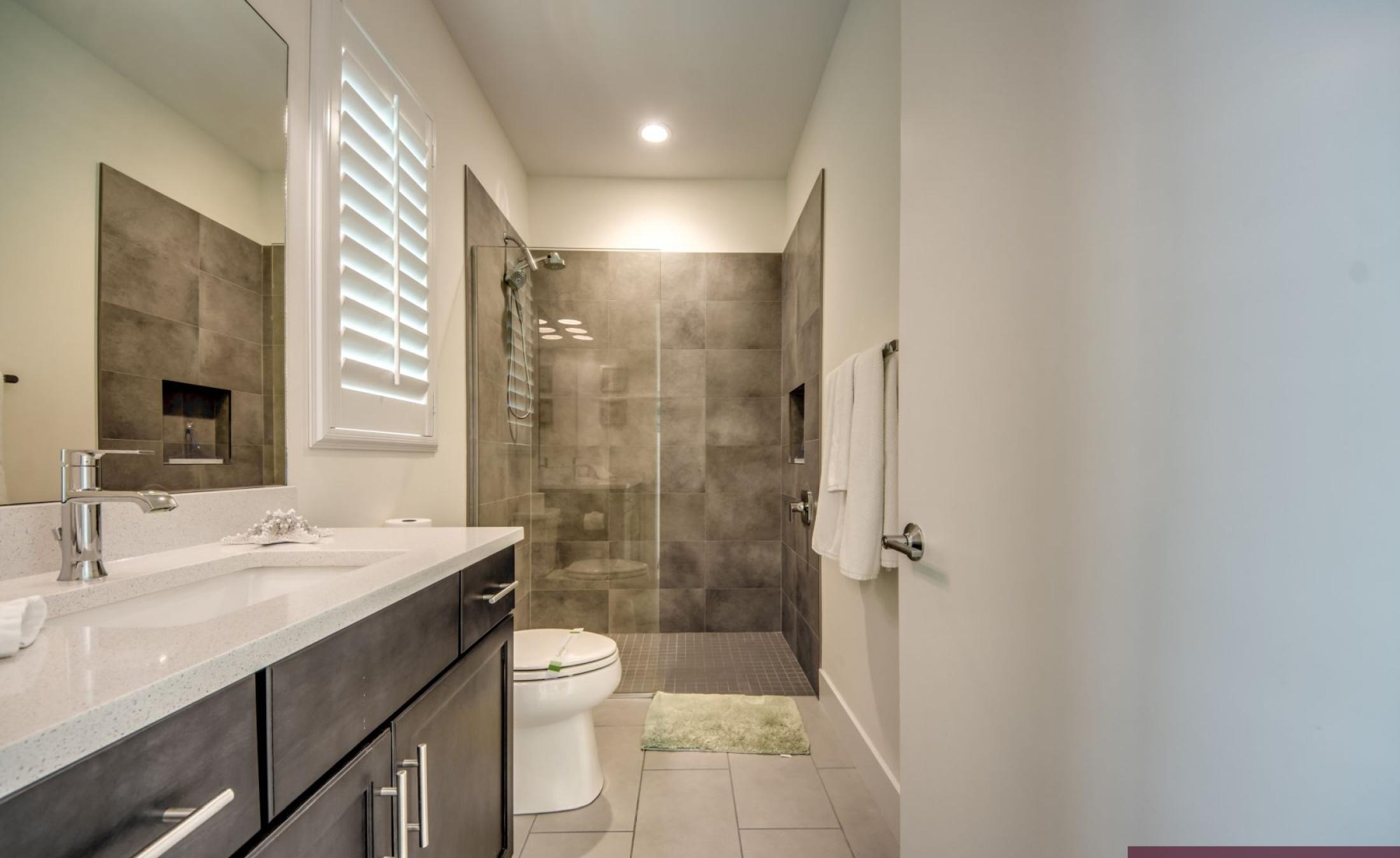 Beheizter Pool mit integriertem Spa auf sonniger Terrasse am Wasser.