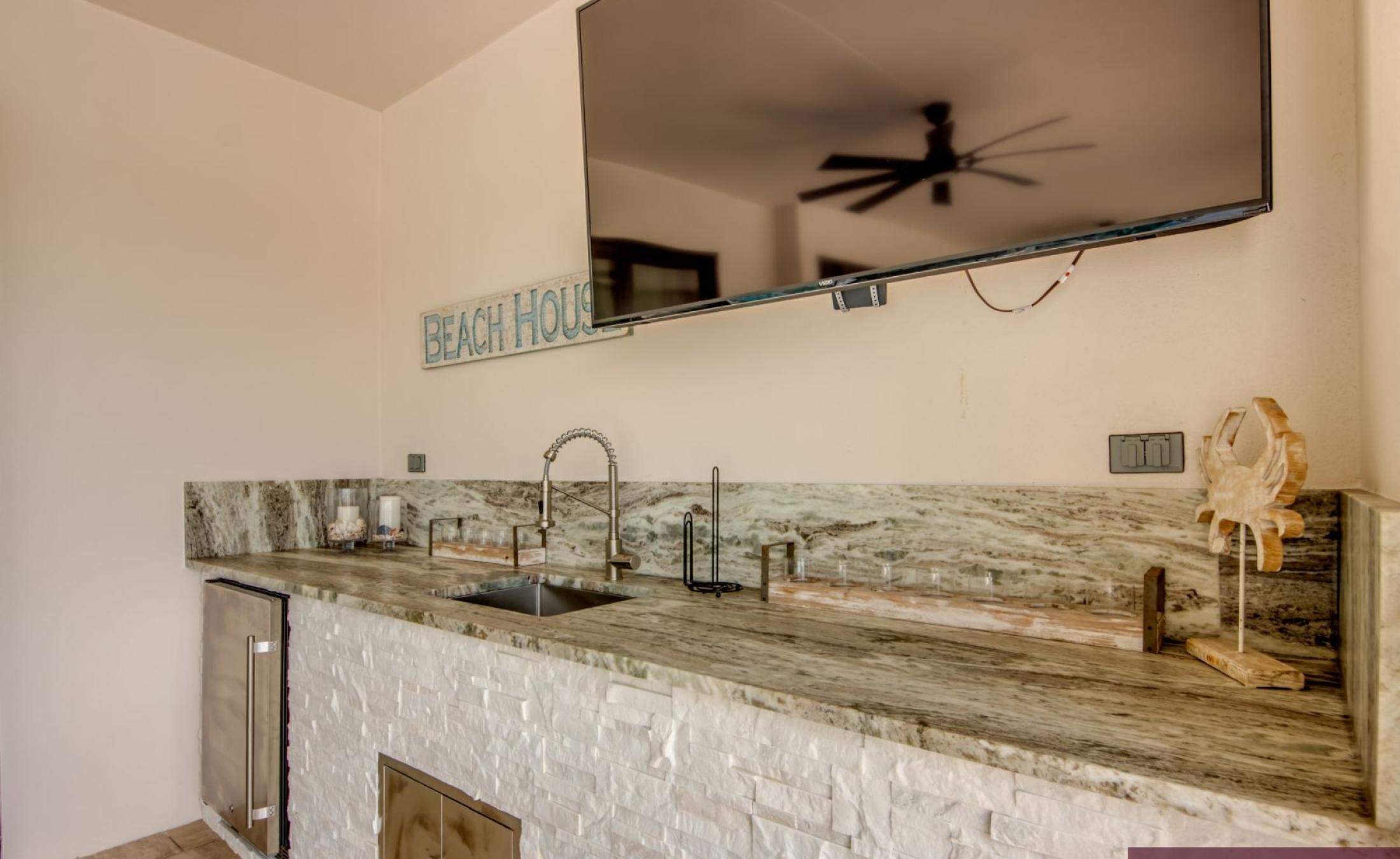 Beheizter Pool mit integriertem Spa und Sonnenterrasse am Wasser.