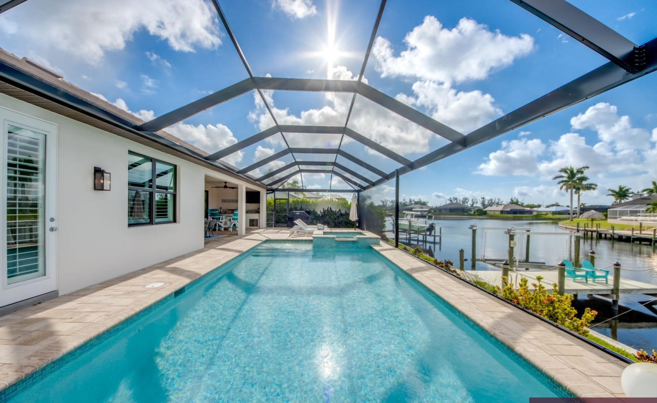 Beheizter Pool mit integriertem Spa und Sonnenterrasse am Wasser.