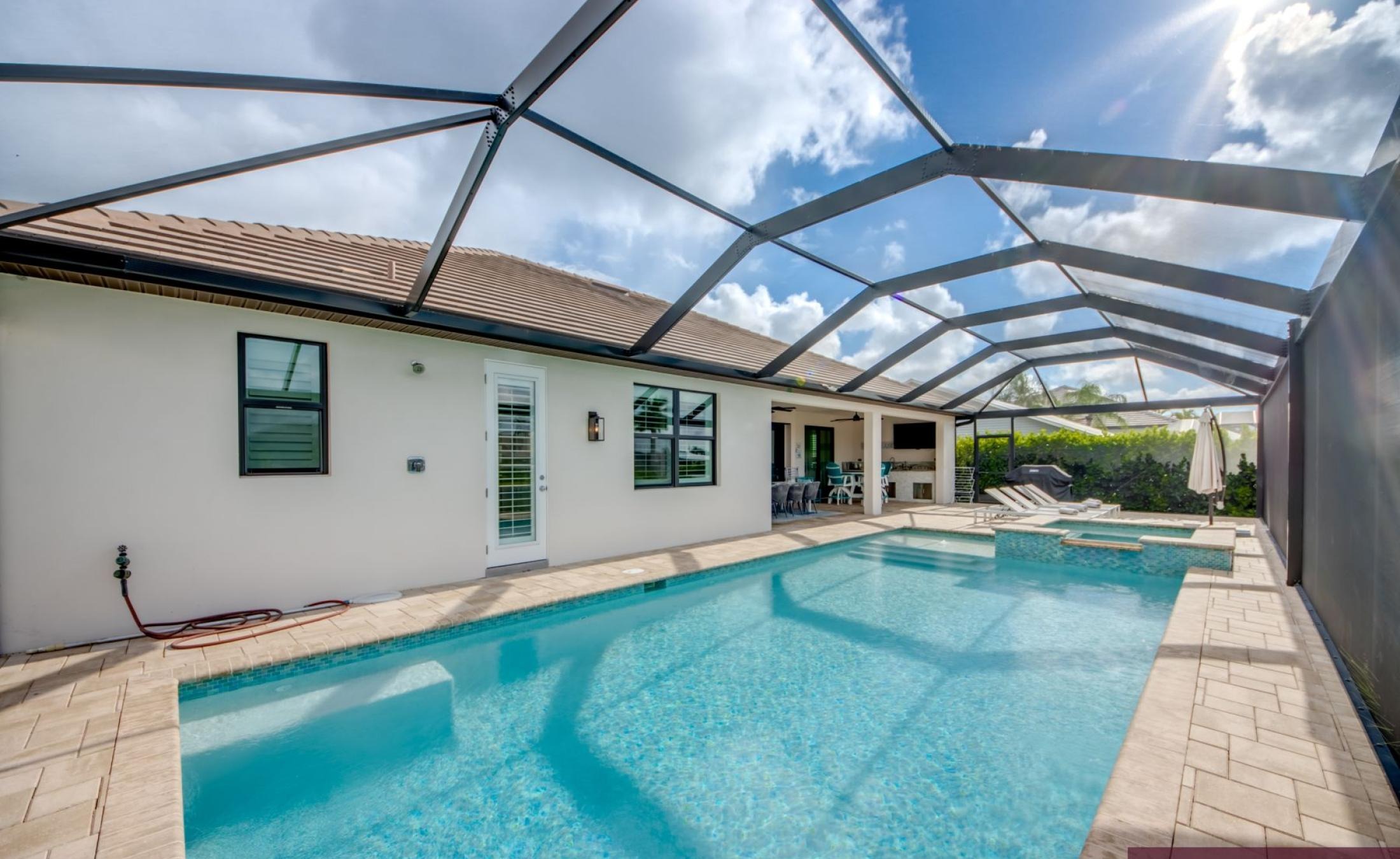 Beheizter Pool mit Spa und Sonnenterrasse am Wasser.