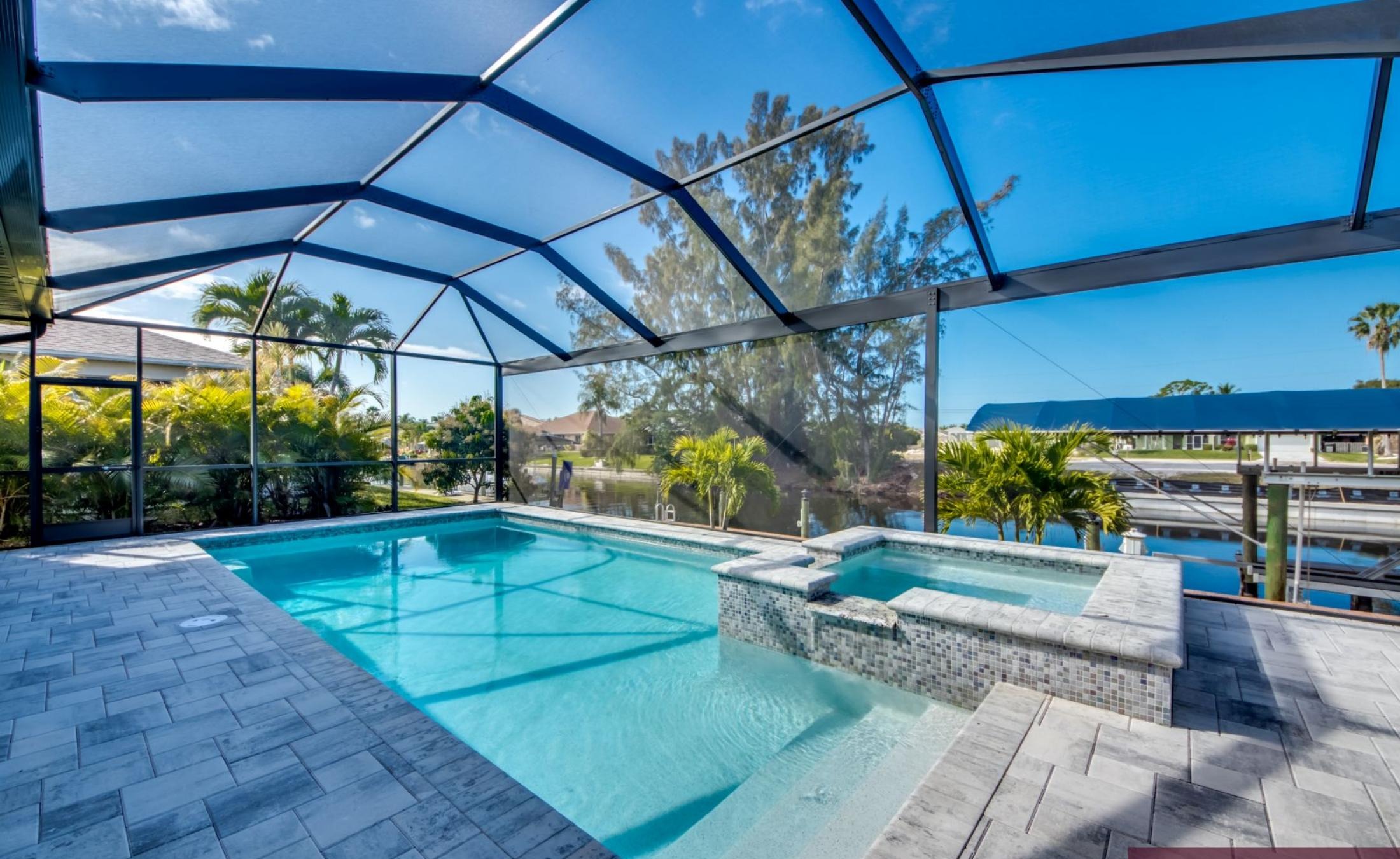 Privates Bootsdock mit Bootslift am Wasserkanal bei Sonnenuntergang.