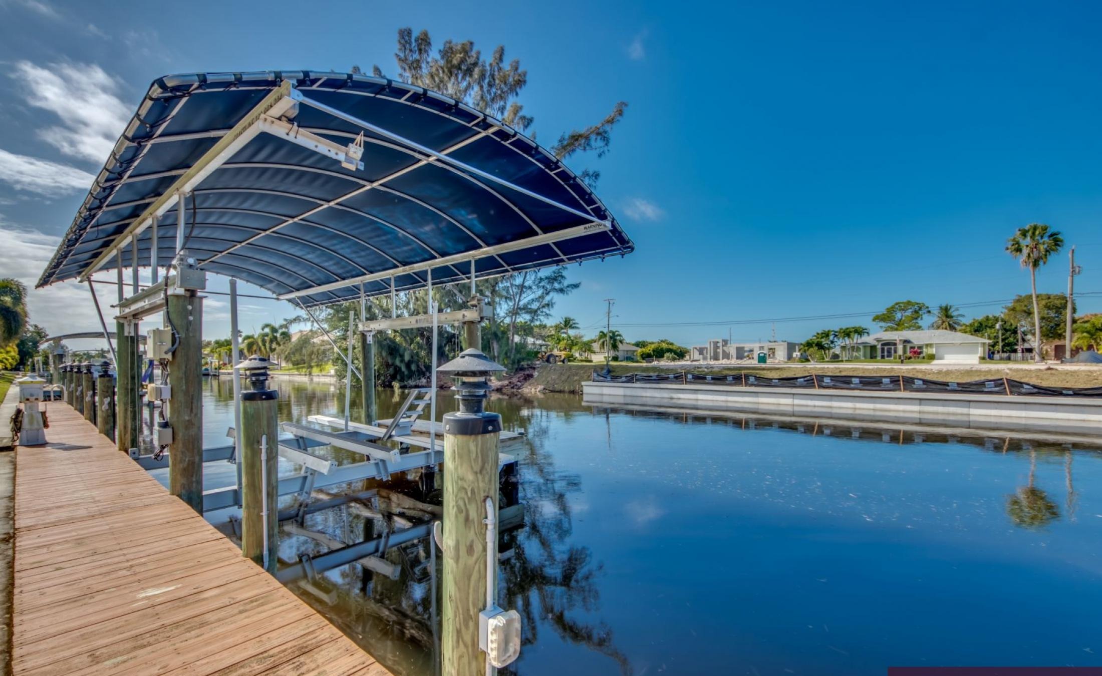 Bootsdock mit Bootslift am Wasserkanal bei Sonnenuntergang.