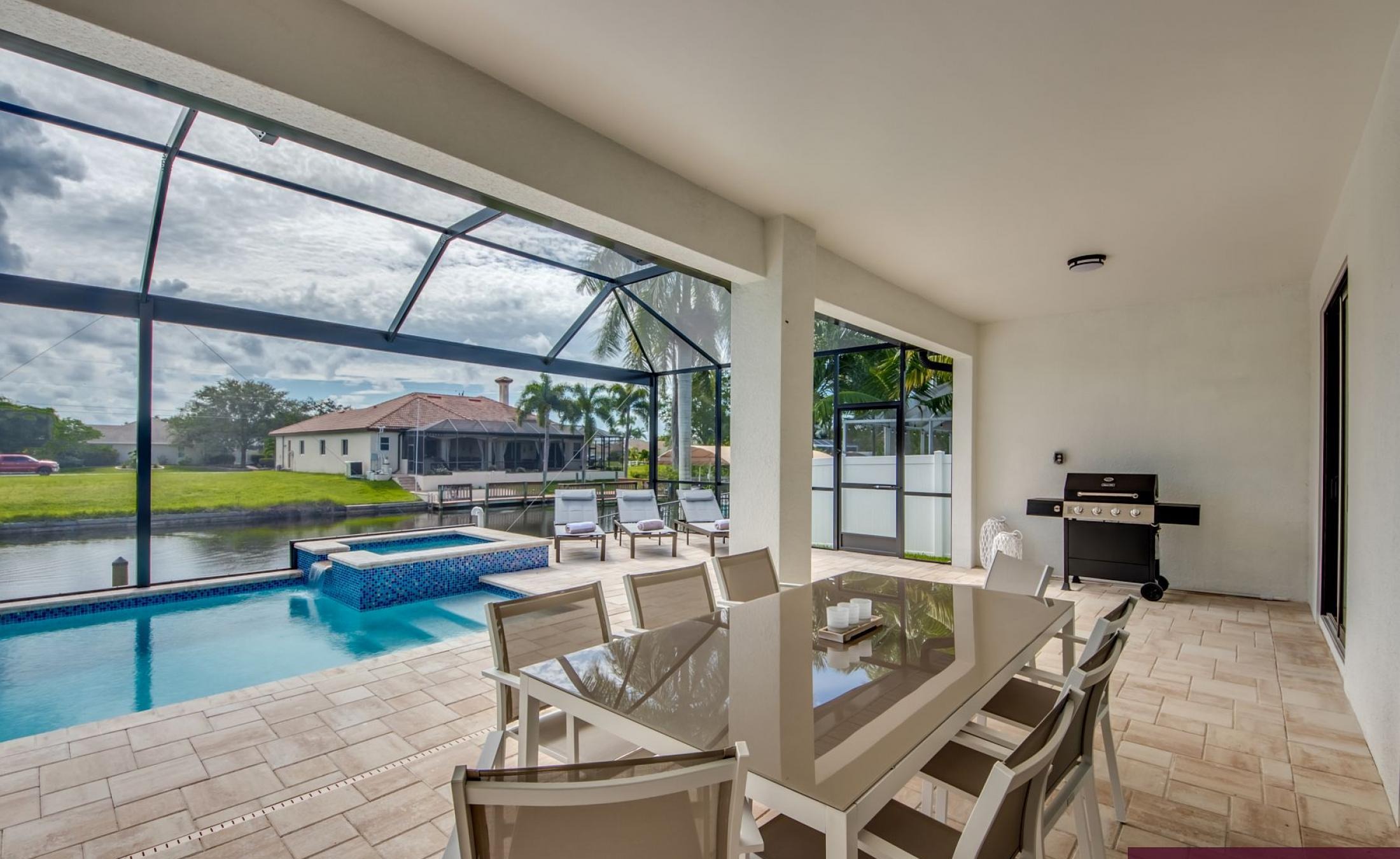 Pool- und Spa-Bereich am Kanal mit Liegen und Bootsdock.