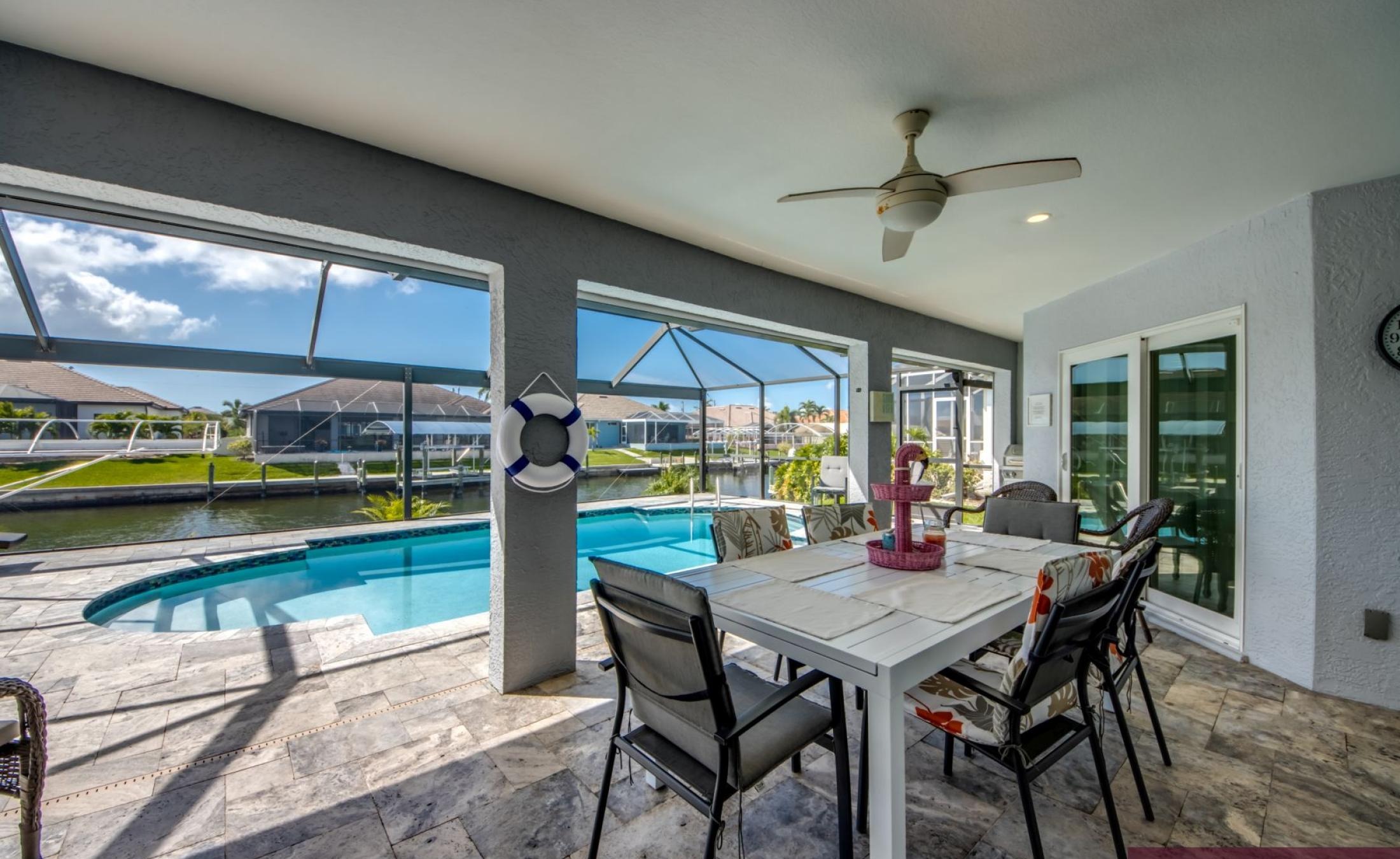 Sonniges Pooldeck mit beheiztem Pool und Blick auf den Kanal mit Bootsdock.