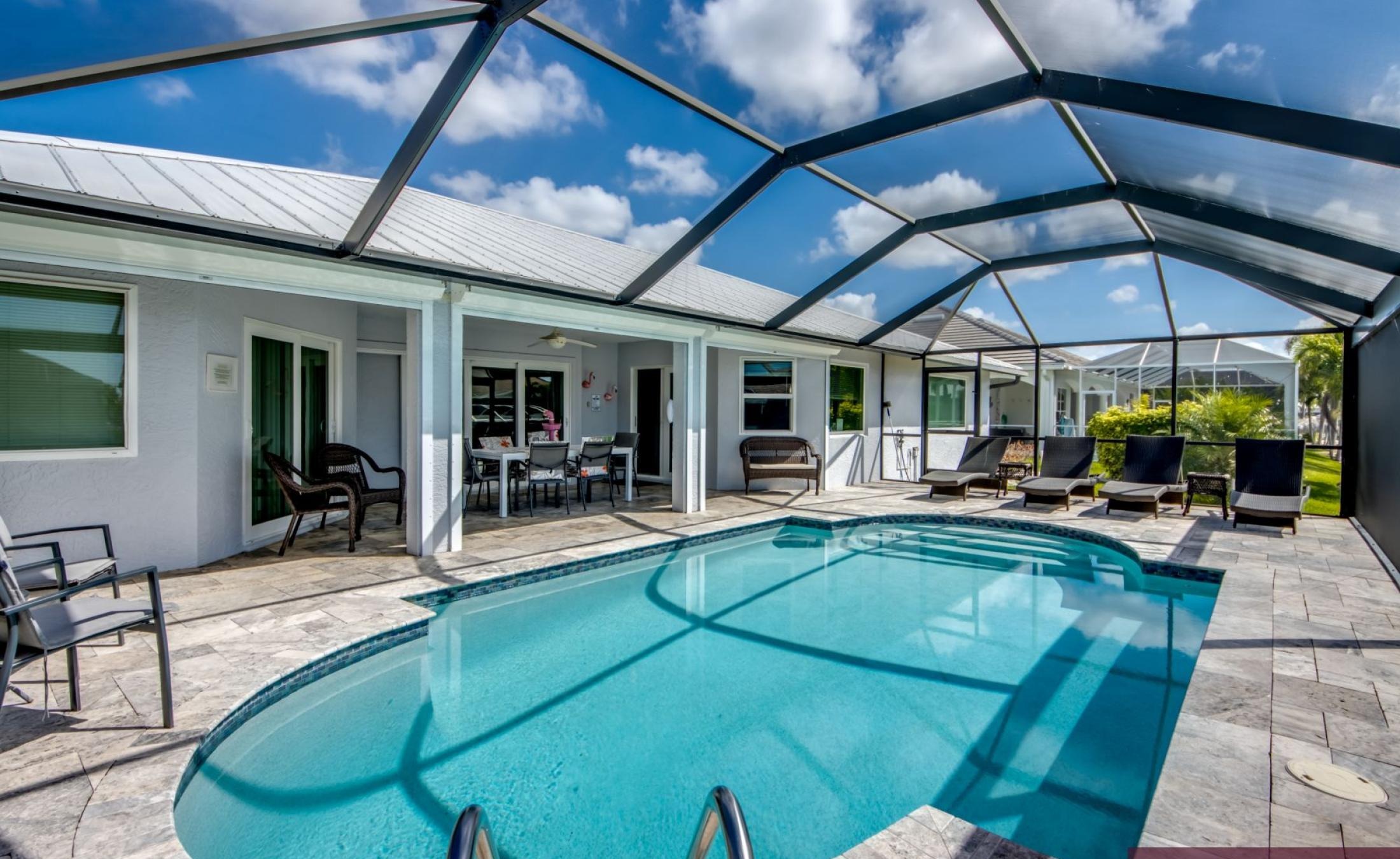 Sonniges Pooldeck mit beheiztem Pool und Blick auf den Kanal.