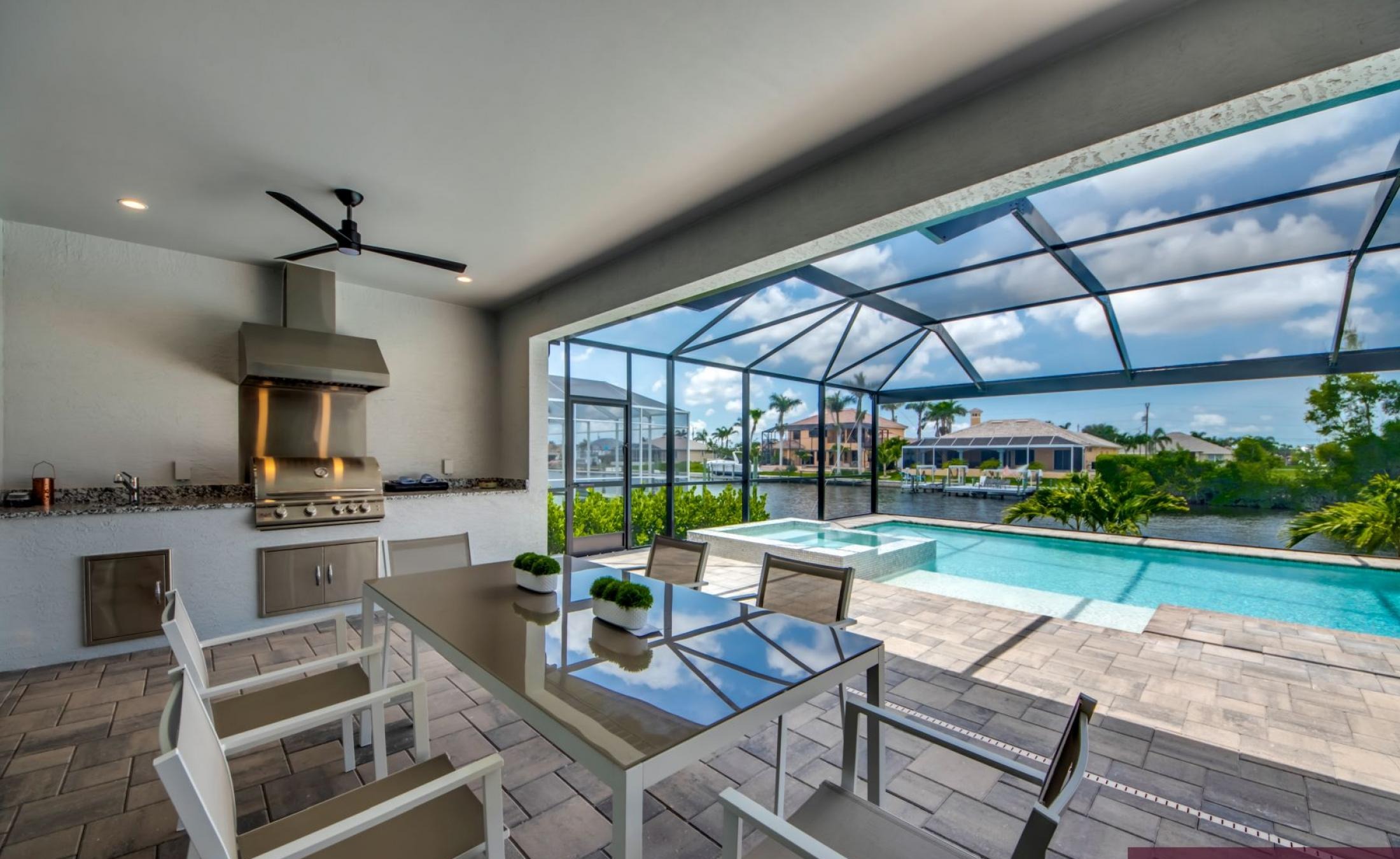 Beheizter Pool mit Spa auf sonnigem Pooldeck am Kanal mit Bootsdock und Lift.