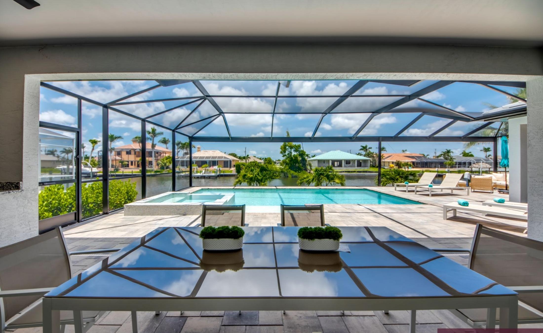 Beheizter Pool mit Spa auf sonnigem Pooldeck am Kanal mit Bootsdock und Lift.