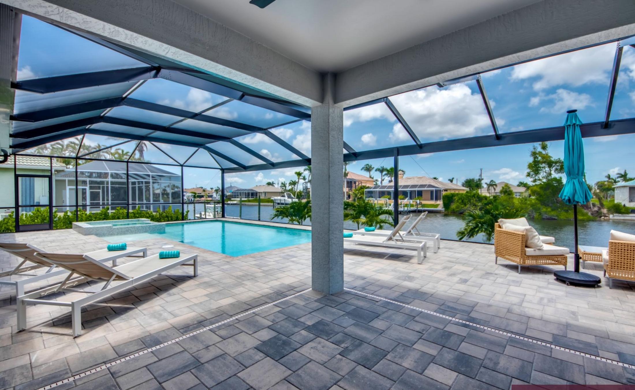 Beheizter Pool mit Spa auf sonnigem Pooldeck am Kanal mit Bootsdock und Lift.