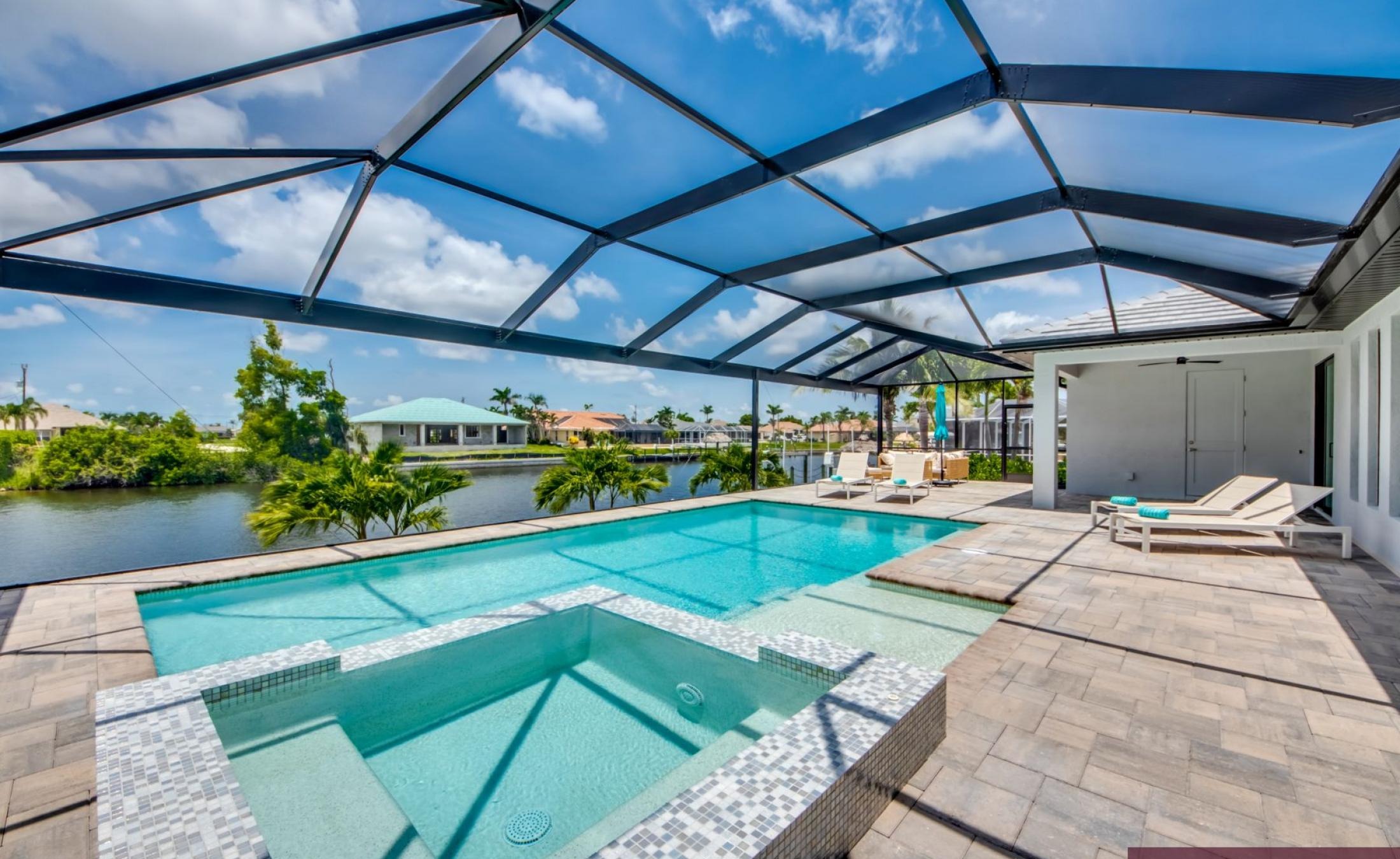 Beheizter Pool mit Spa auf sonnigem Pooldeck am Kanal.