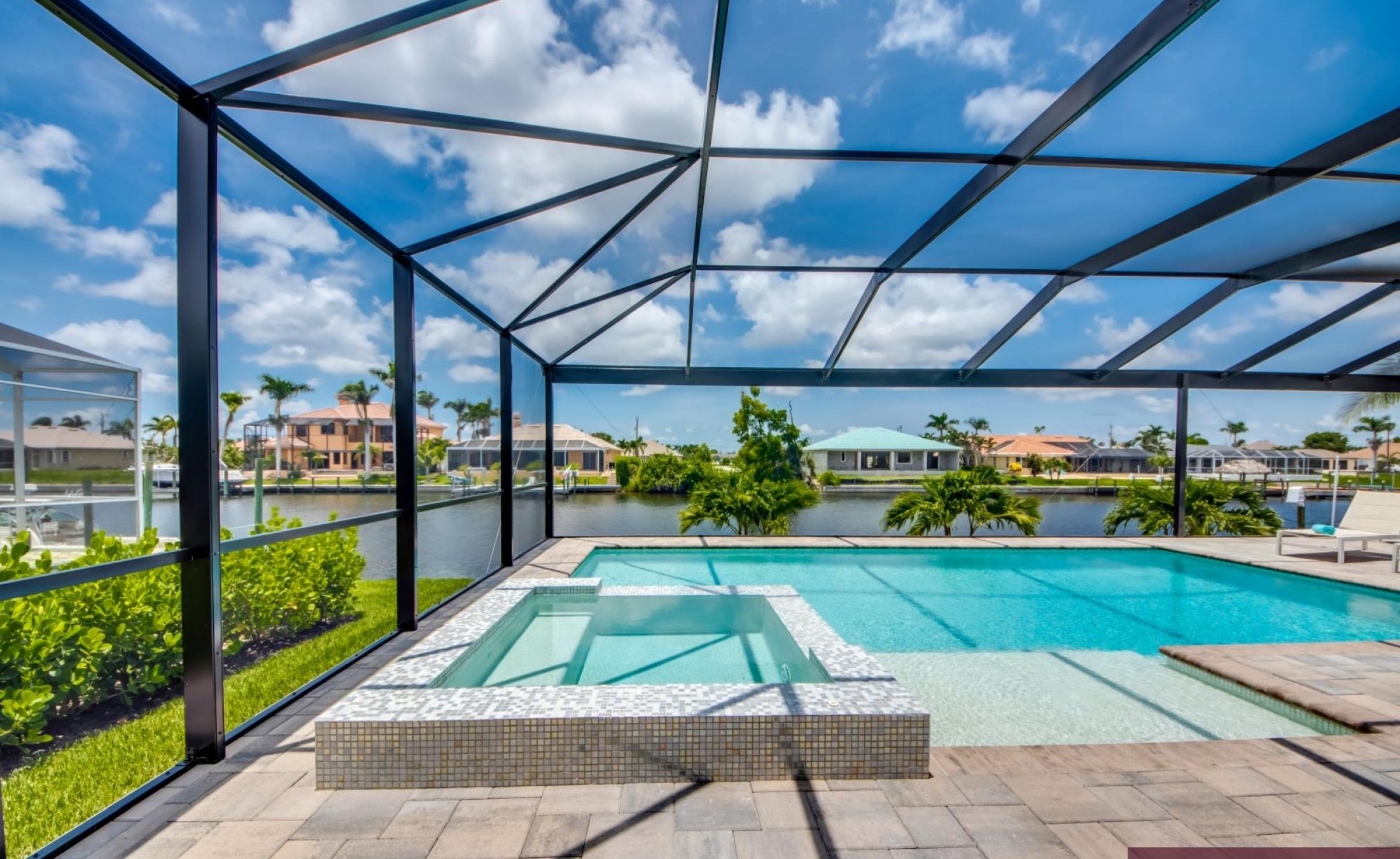 Beheizter Pool mit Spa auf sonnigem Pooldeck am Kanal mit Bootsdock und Lift.