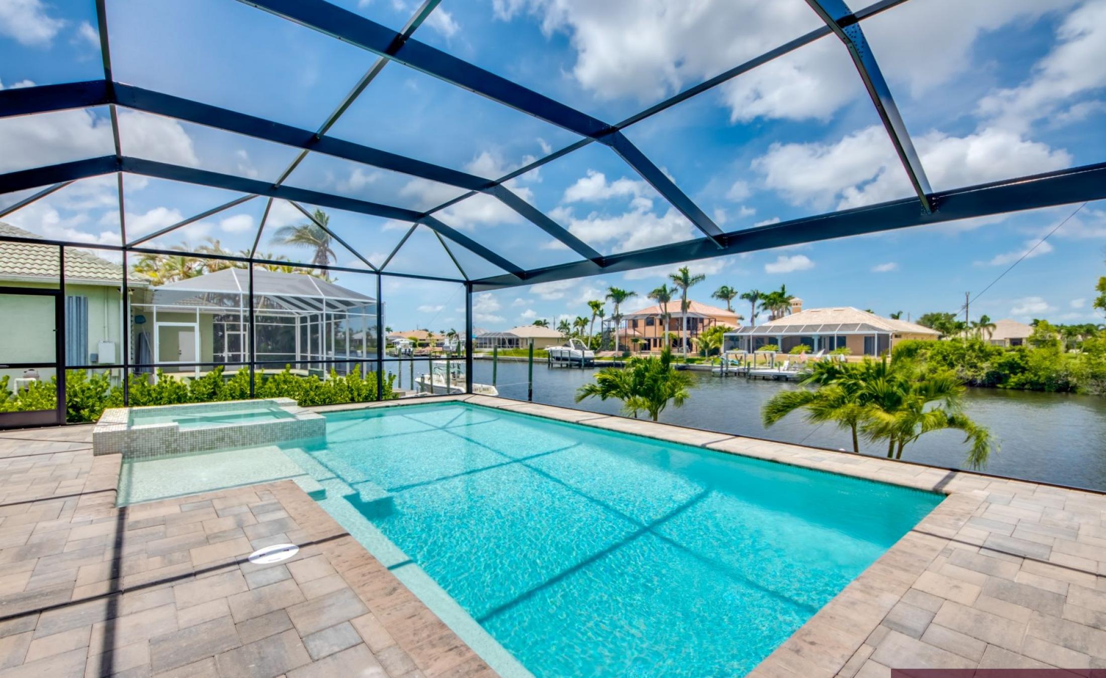 Beheizter Pool mit Spa auf sonnigem Pooldeck am Kanal, mit Bootsdock und Bootslift.