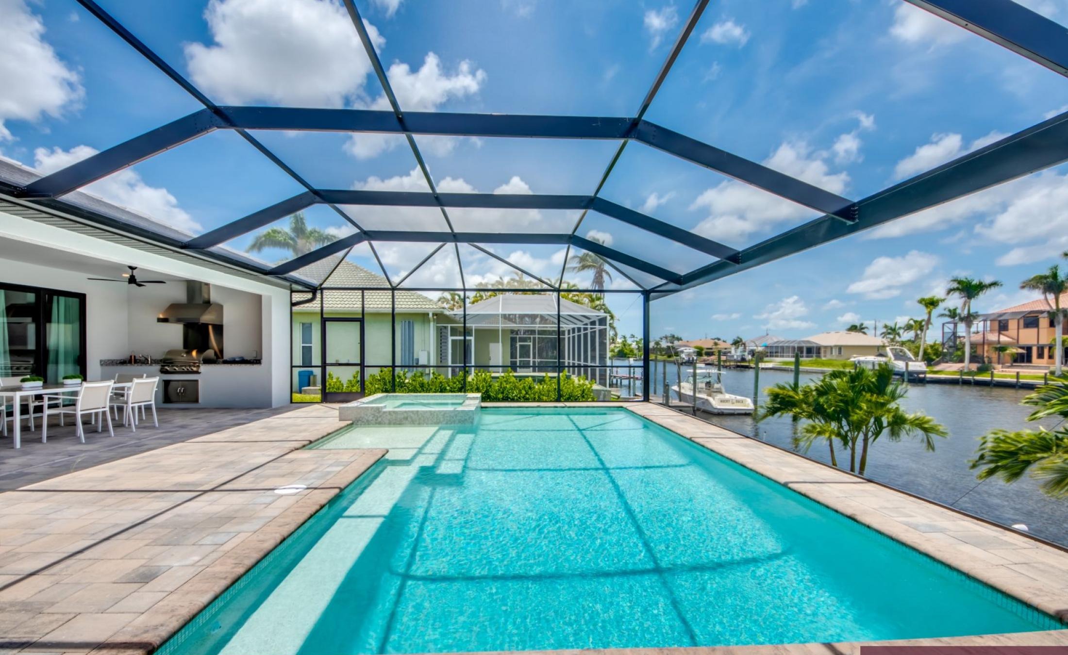 Beheizter Pool mit Spa auf sonnigem Pooldeck am Kanal mit Bootsdock und Lift.