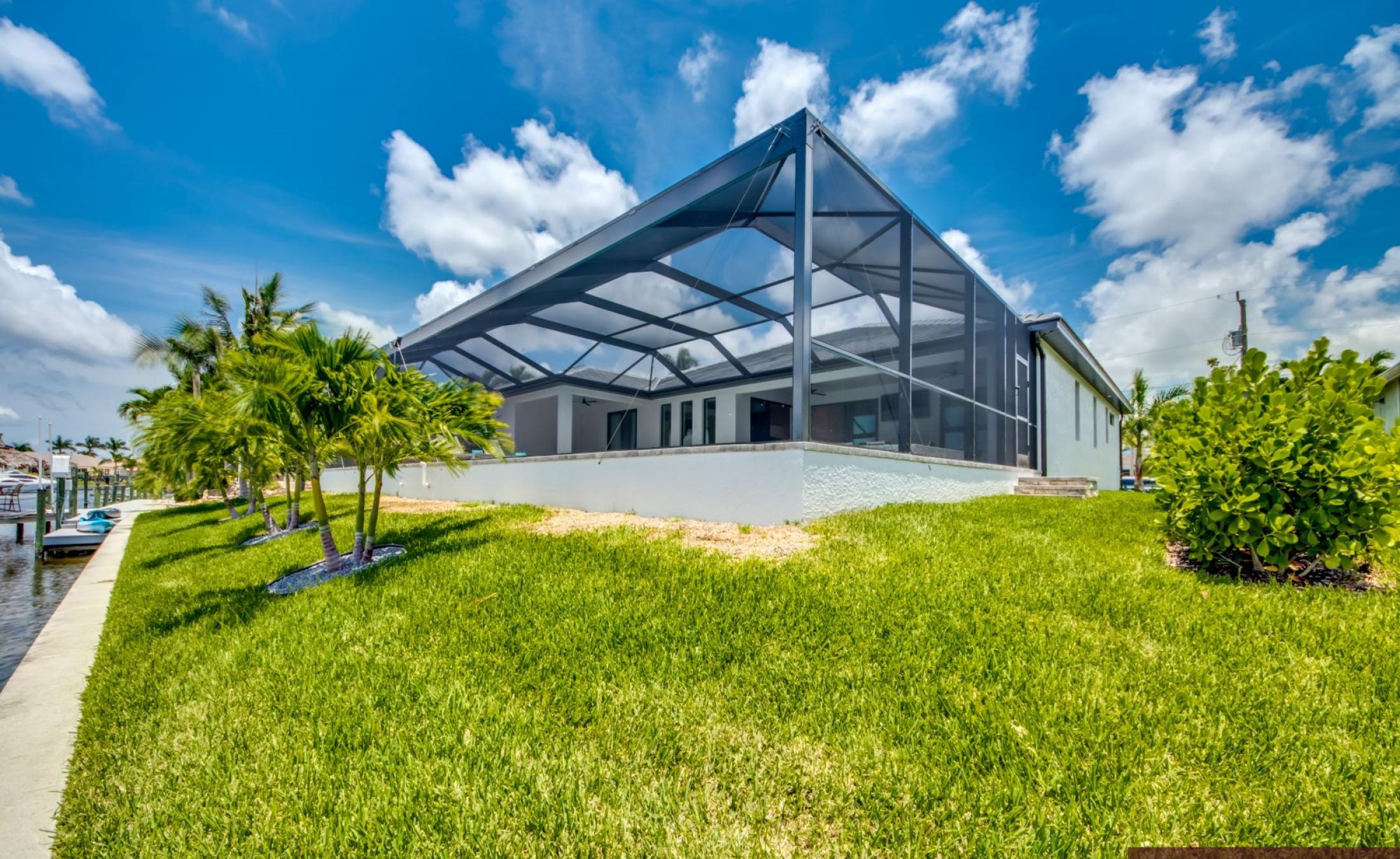 Beheizter Pool mit Spa auf sonnigem Pooldeck am Kanal mit Bootsdock und Lift.