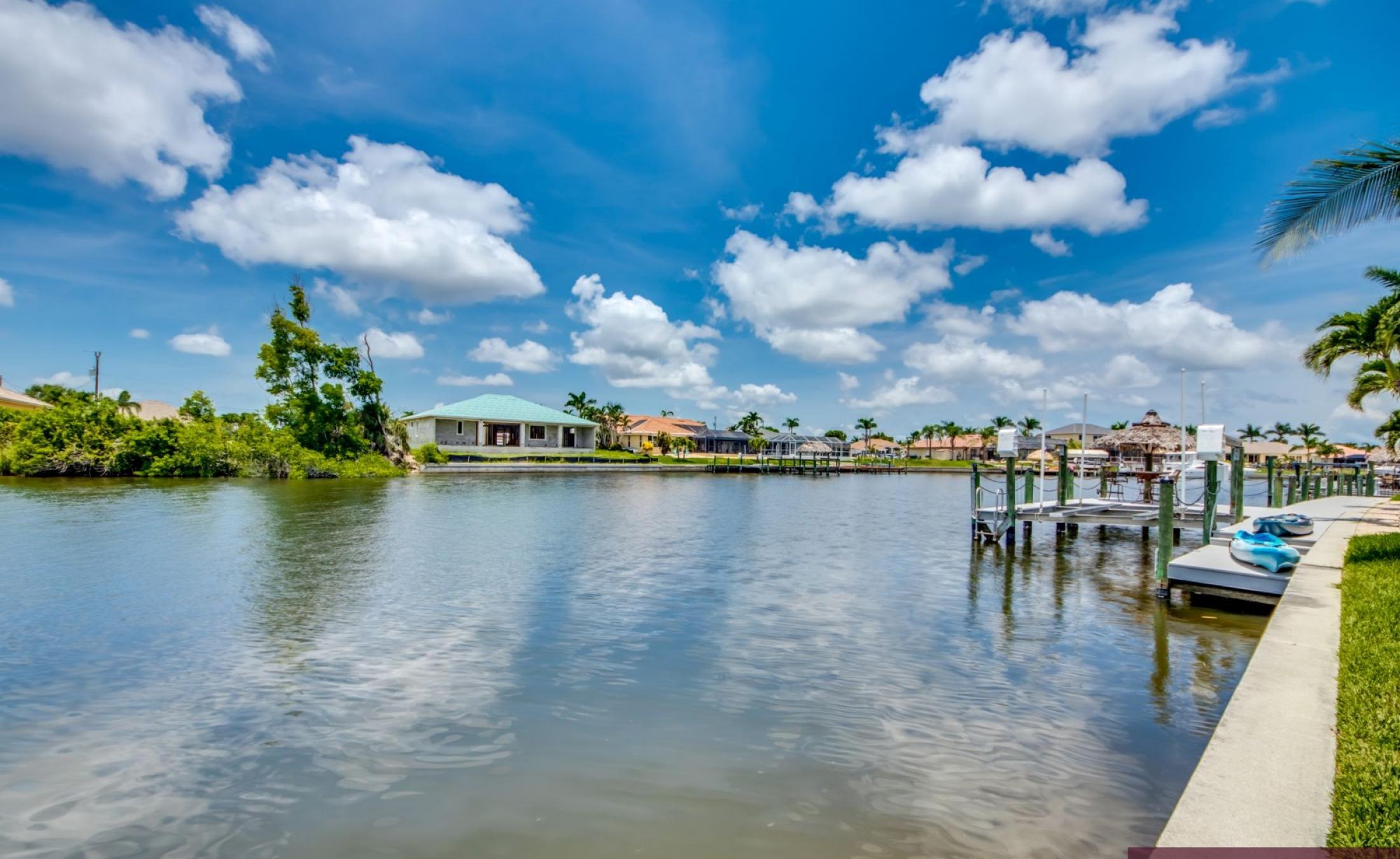 Beheizter Pool mit Spa auf sonnigem Pooldeck am Kanal mit Bootsdock und Lift.