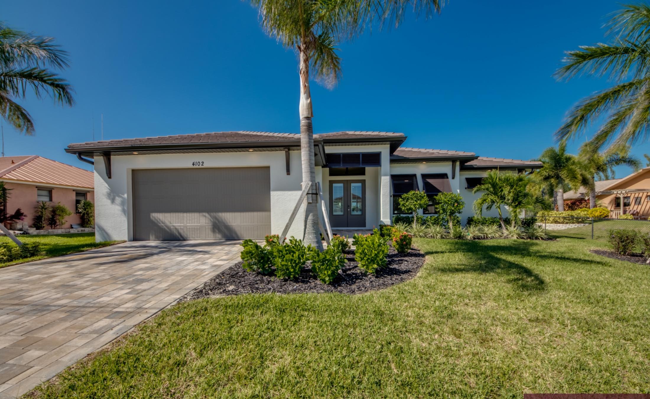 Moderner Poolbereich mit Spa und Blick auf den Kanal bei Sonnenuntergang.