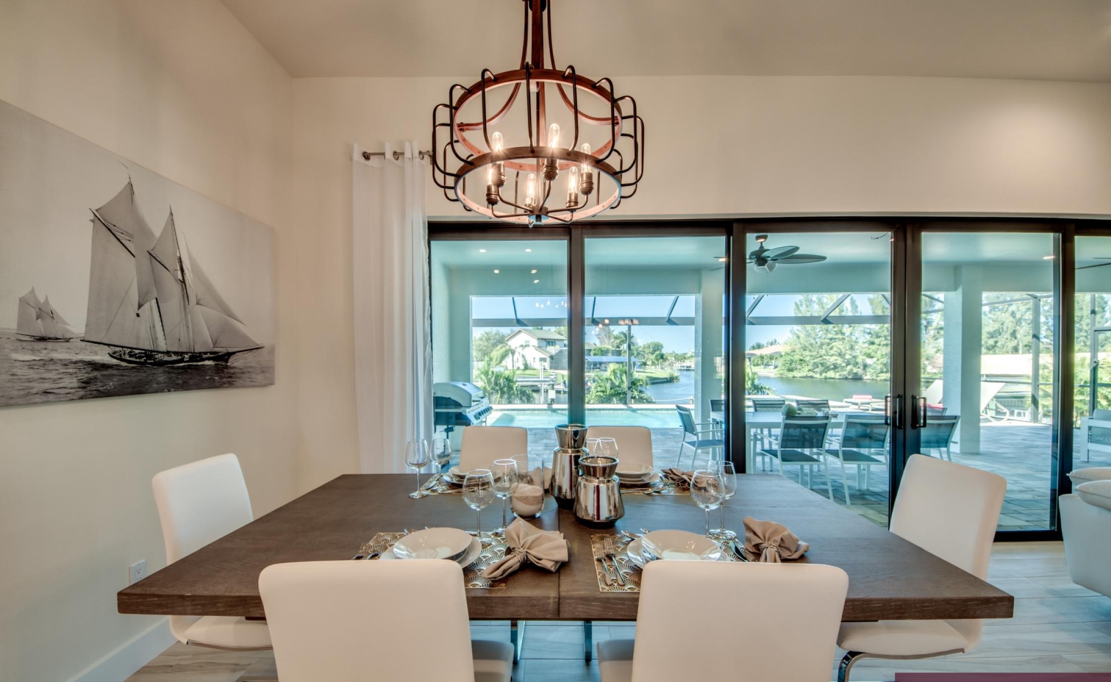 Moderner Pool mit Spa und Blick auf den Kanal bei Sonnenuntergang.