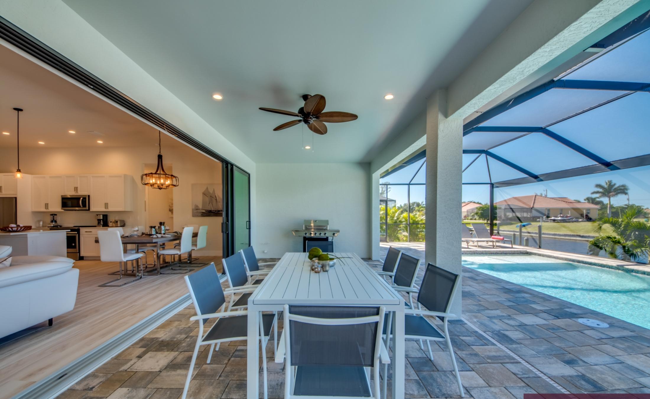 Pool- und Spa-Bereich am Kanal mit Bootsdock und Liegen bei Sonnenuntergang.